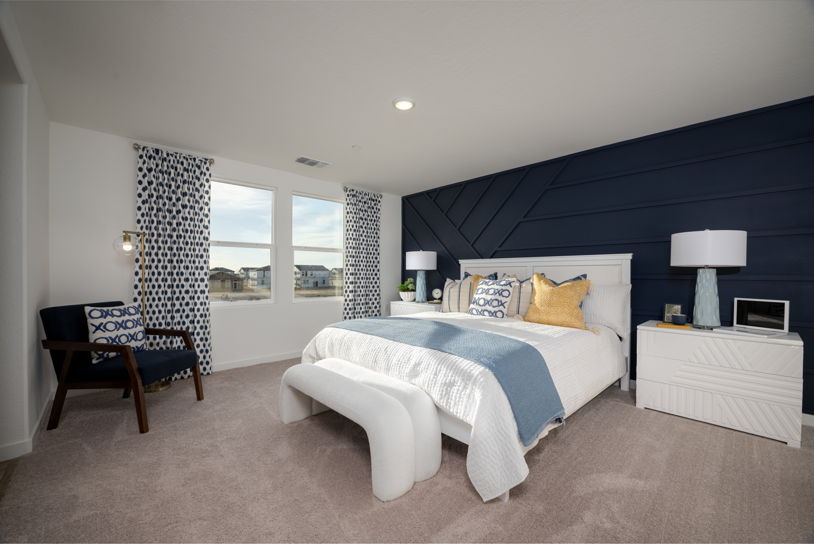 A bedroom with a bed and a bench.