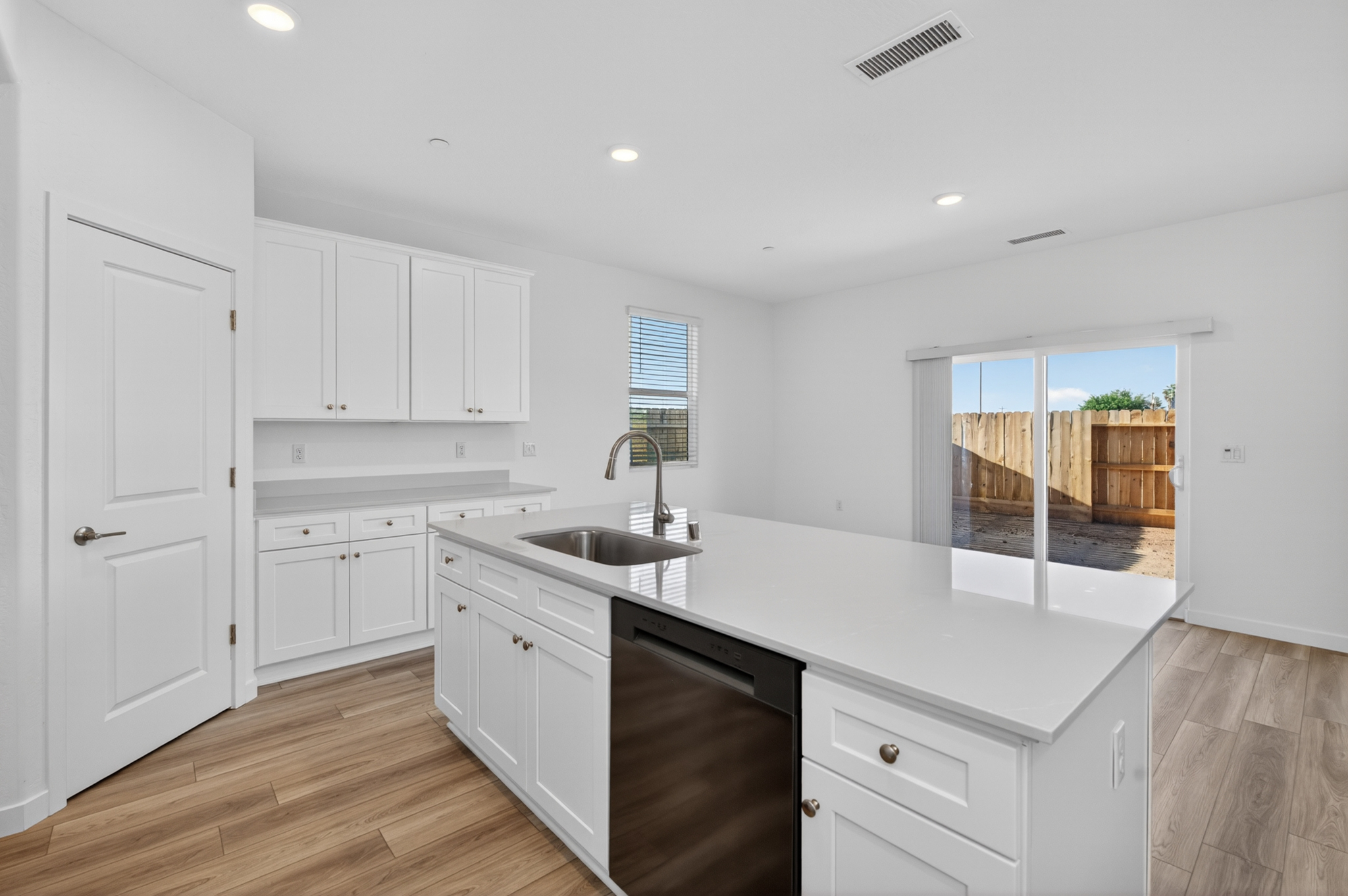 A kitchen with white cabinets.