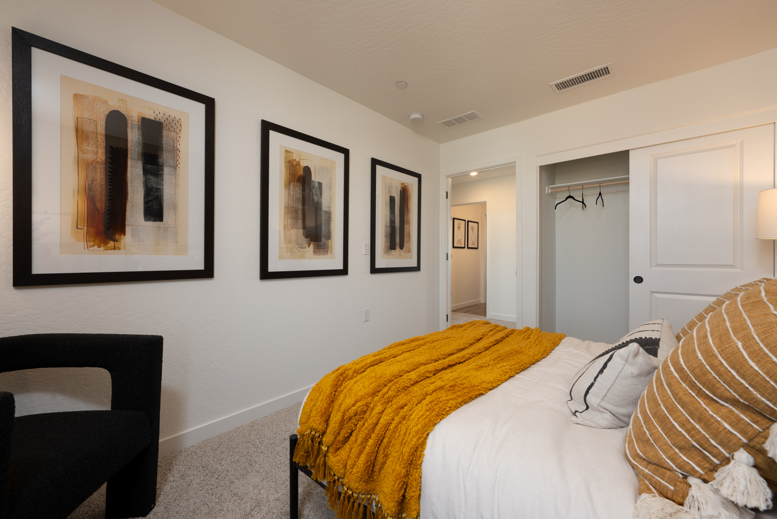 A bedroom with a bed and a chair.