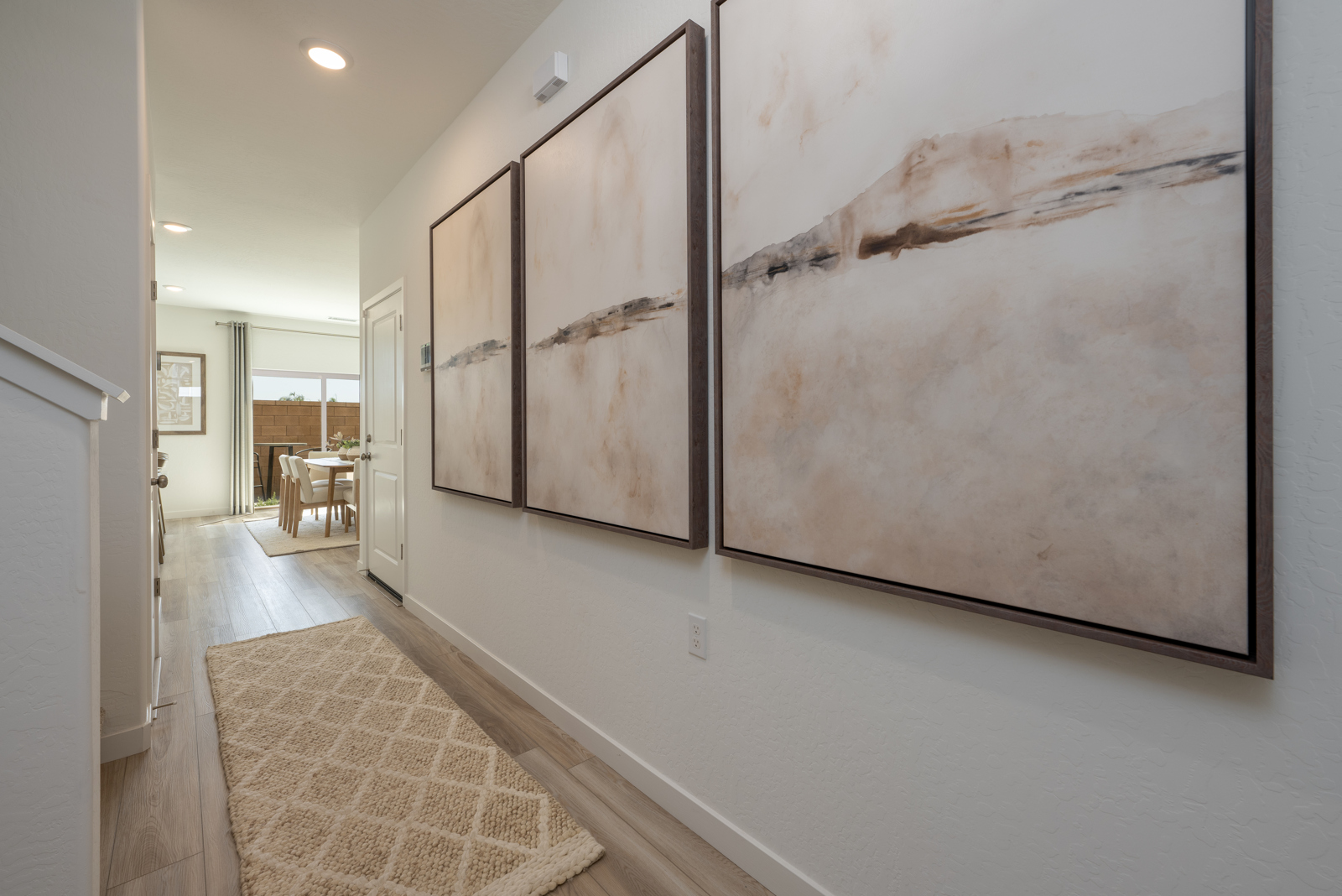 A room with a wall of paintings.