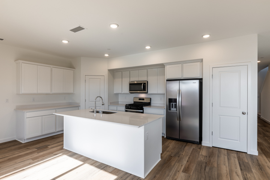 A kitchen with white cabinets.