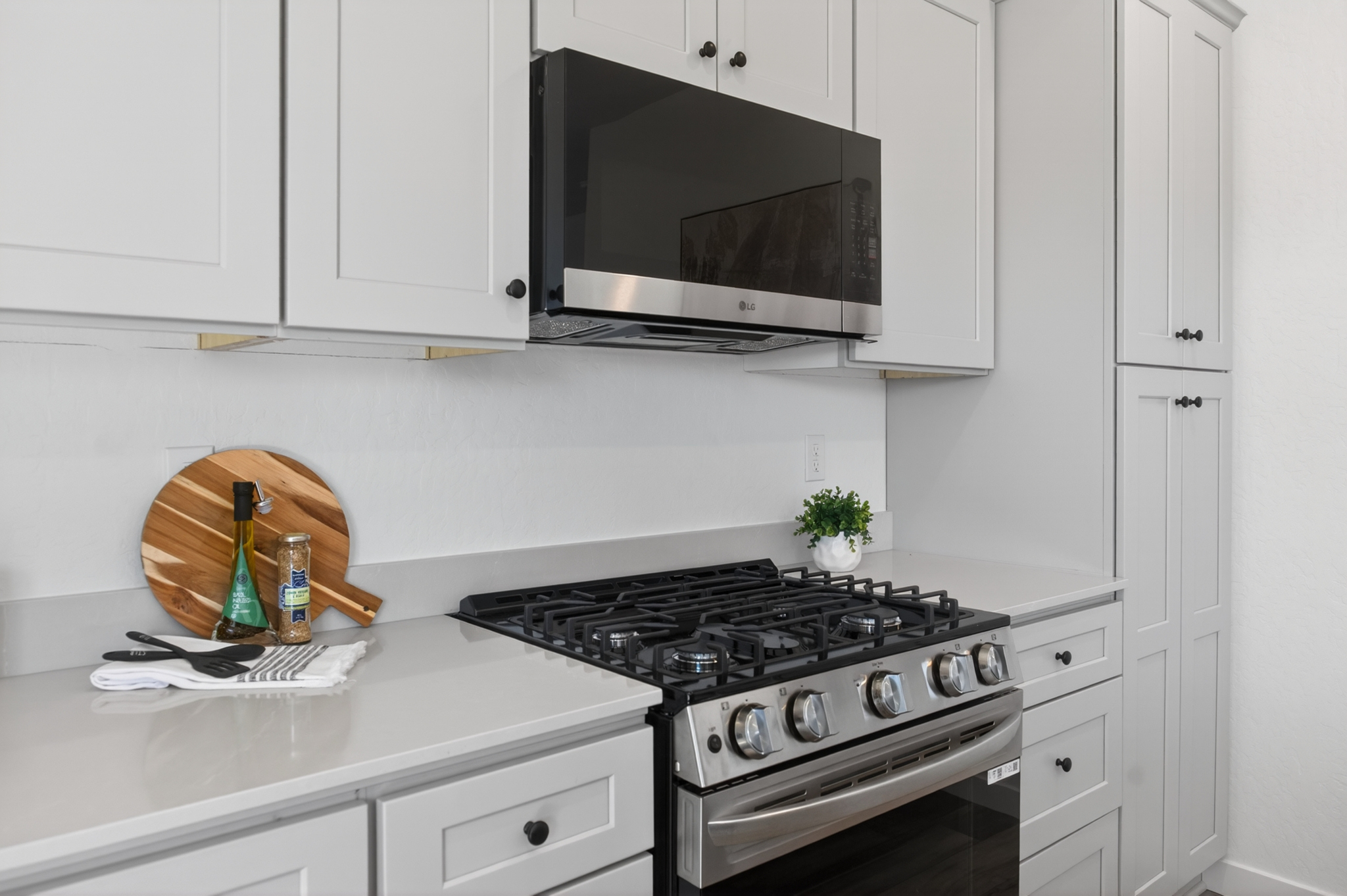 A kitchen with white cabinets.