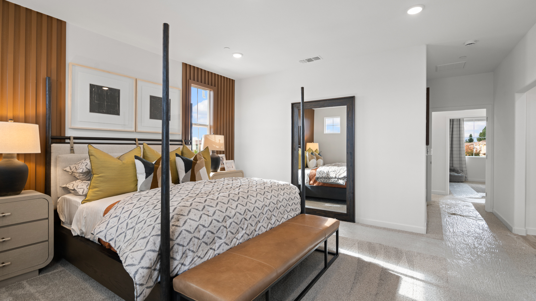 A bedroom with a bed and a mirror.