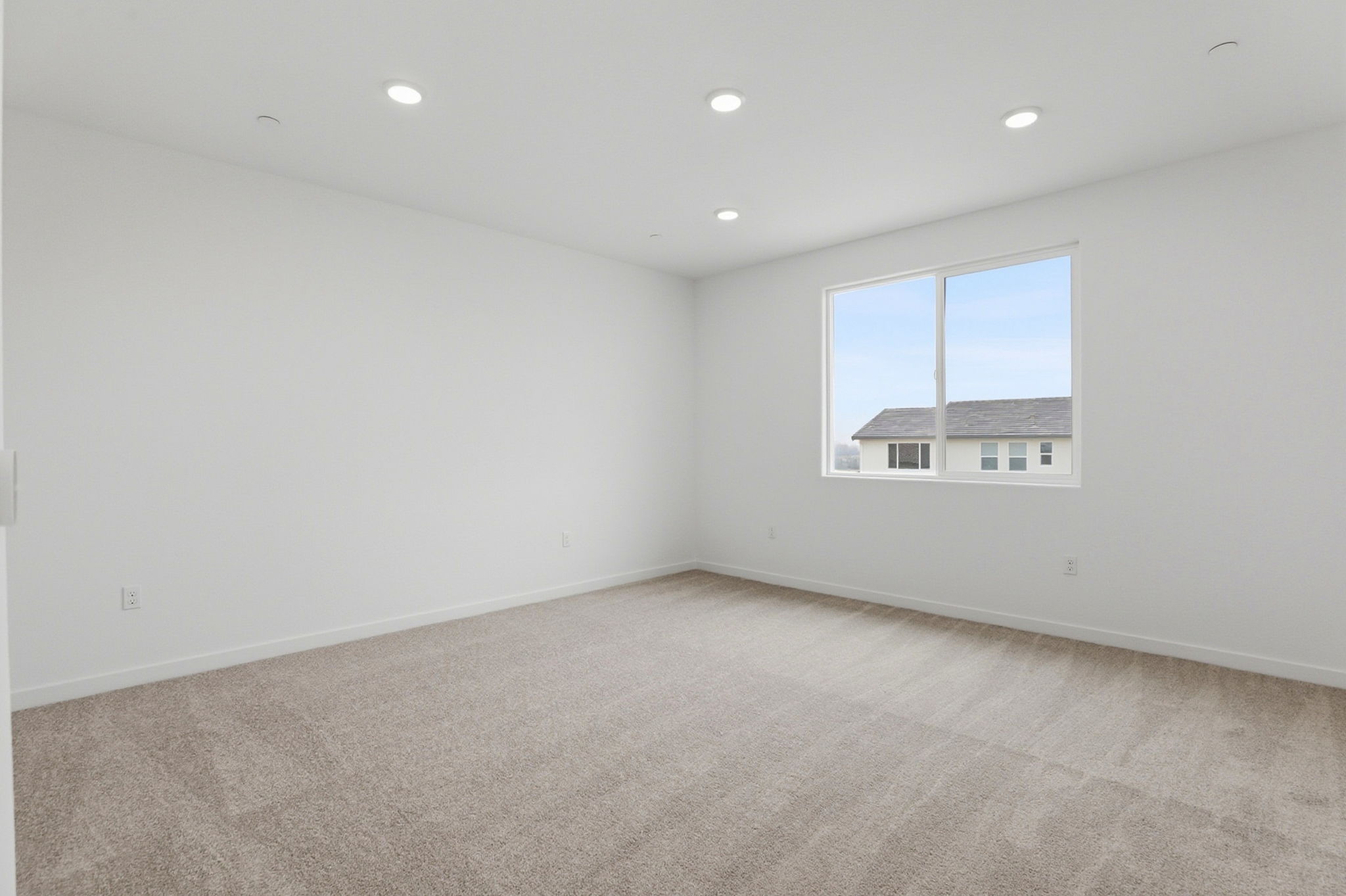 A room with a window and a carpet.