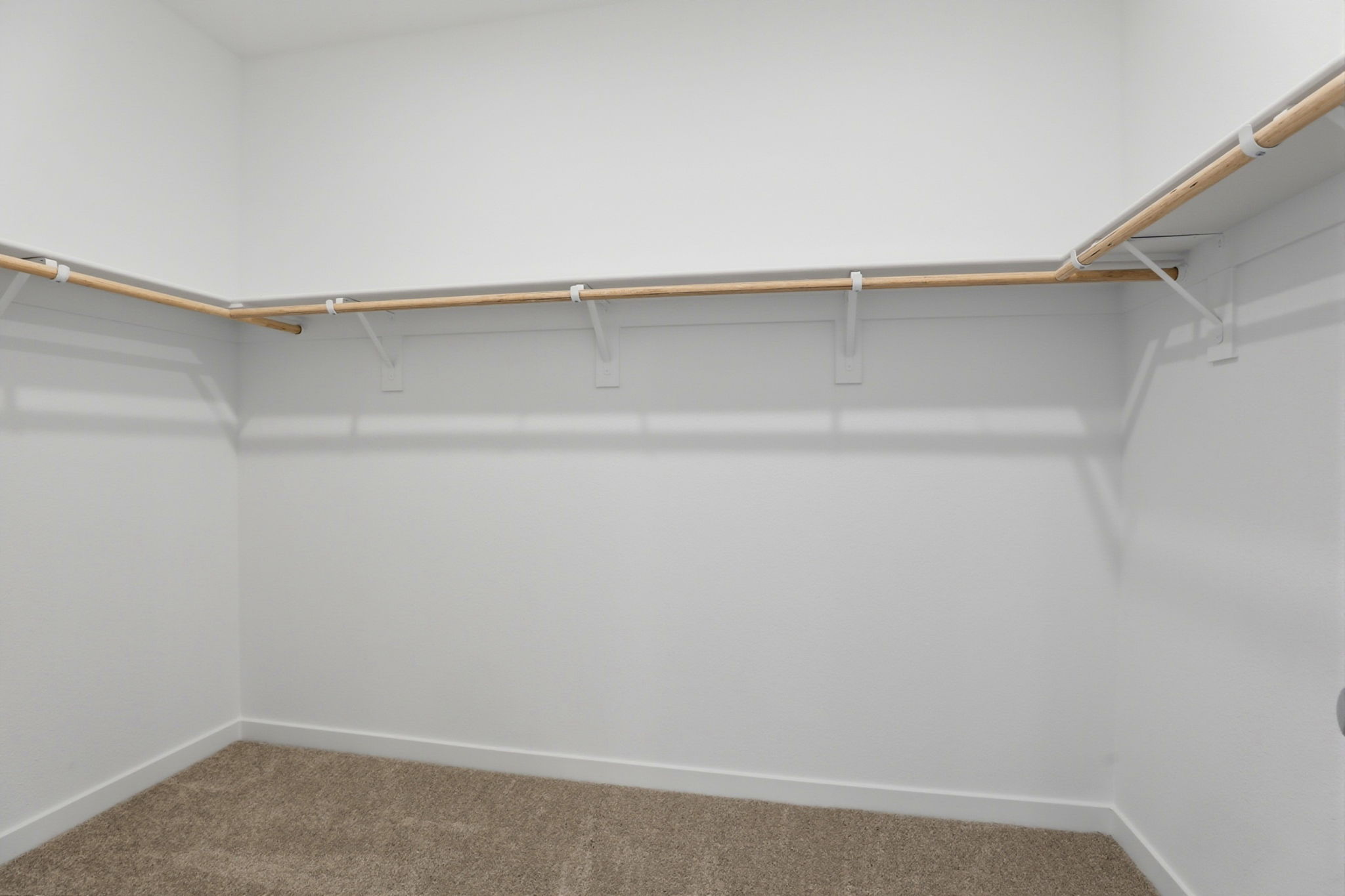 A white wall with a metal bar.