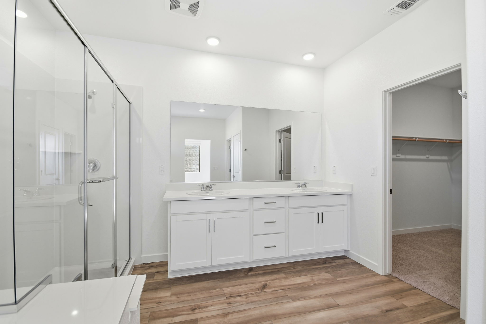 A bathroom with white cabinets.