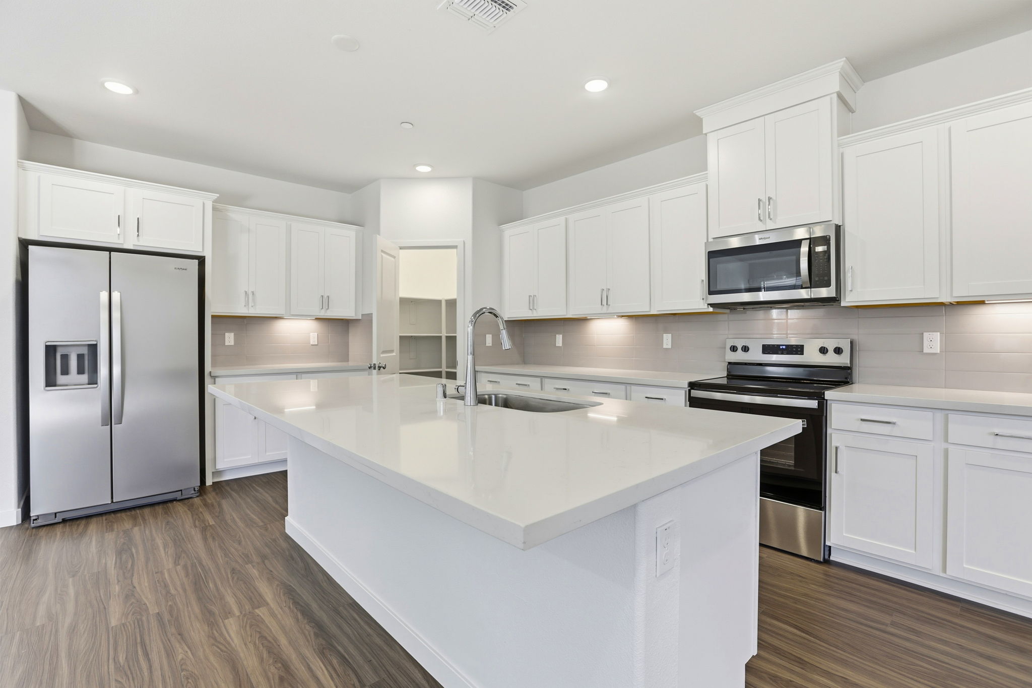 A kitchen with white cabinets.