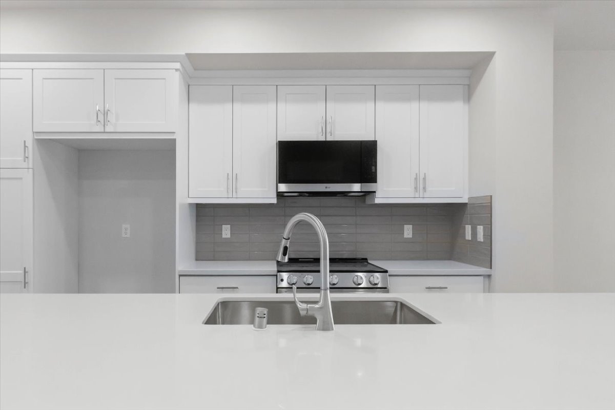 A kitchen with white cabinets.