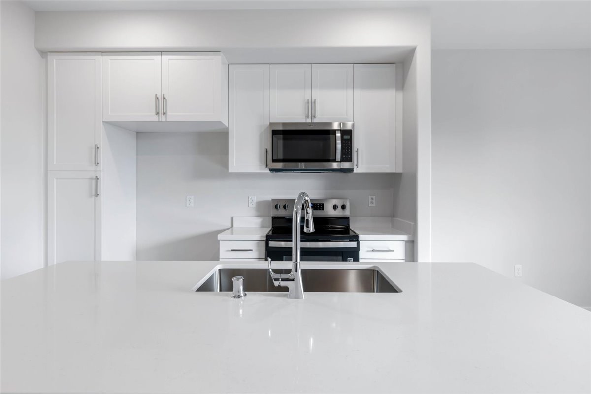 A kitchen with white cabinets.