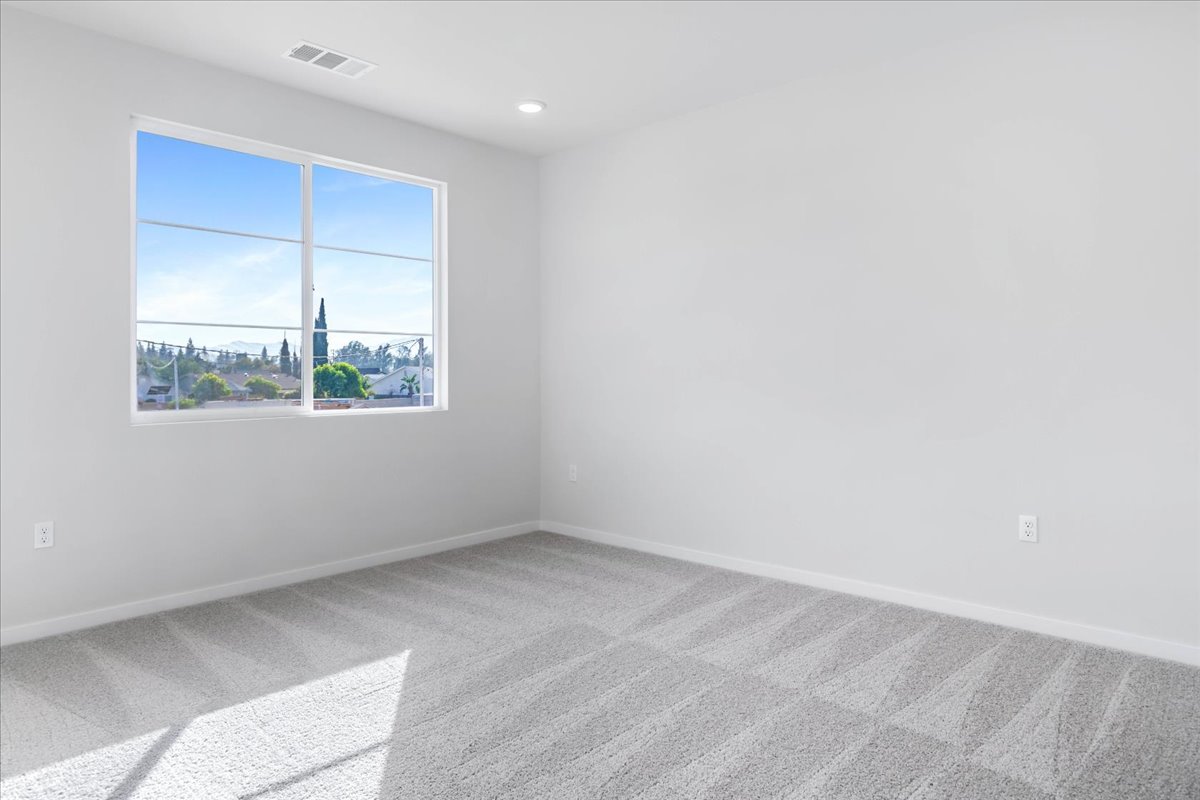 A room with a window and a rug.