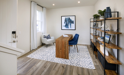 A living room with a table and chairs.