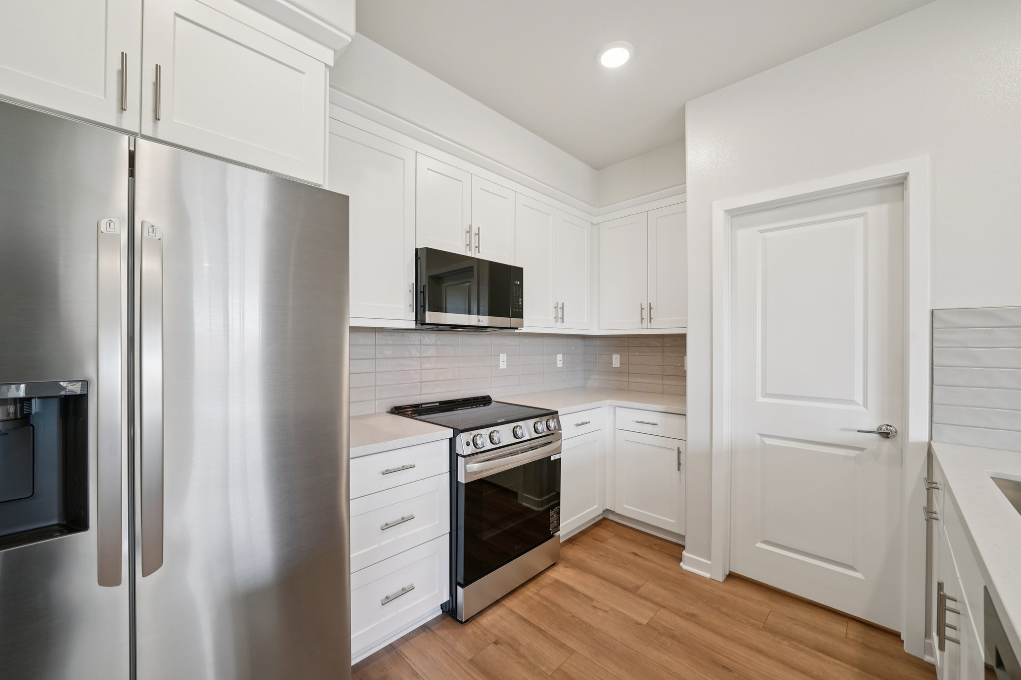 A kitchen with white cabinets.
