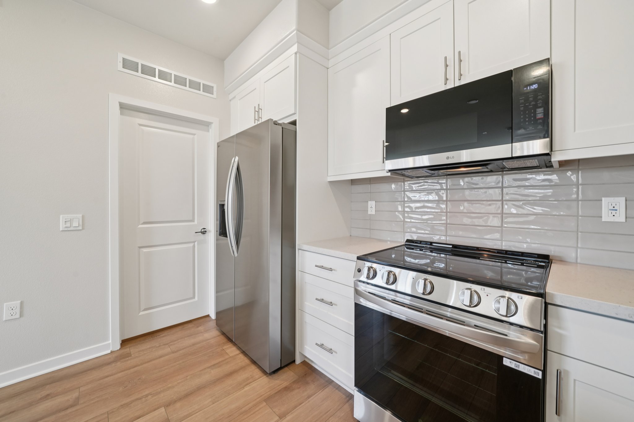 A kitchen with white cabinets.