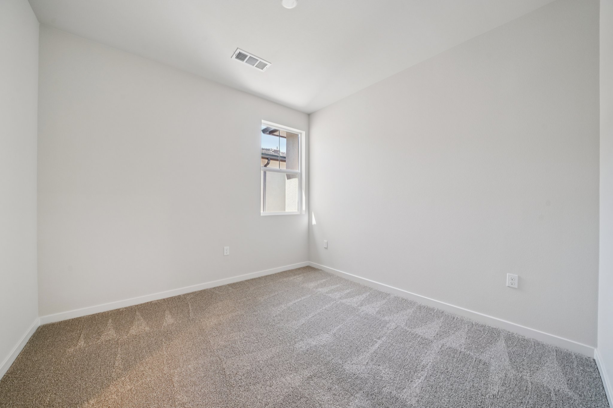 A room with a carpet and a window.