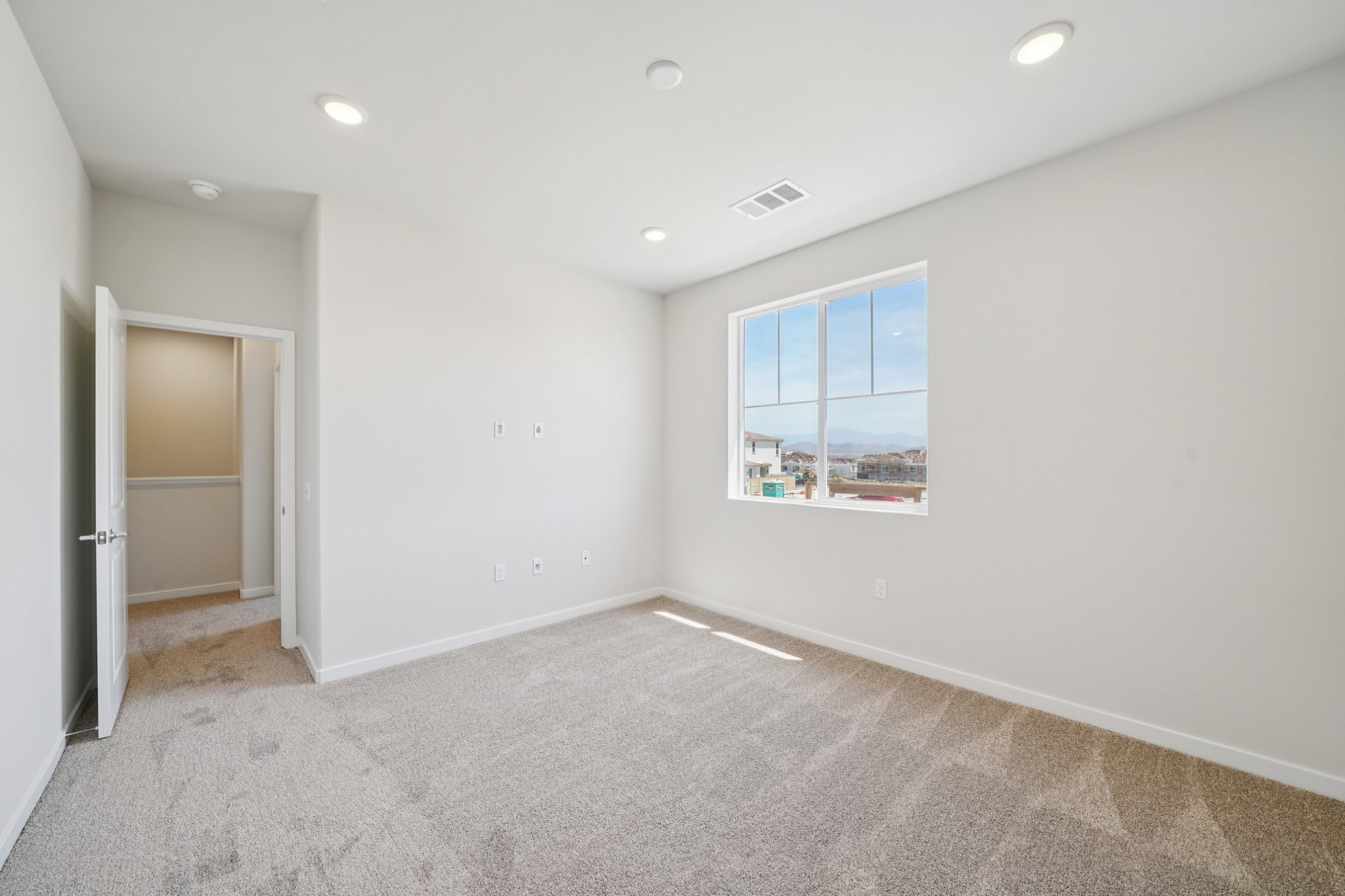 A room with a window and a carpet.