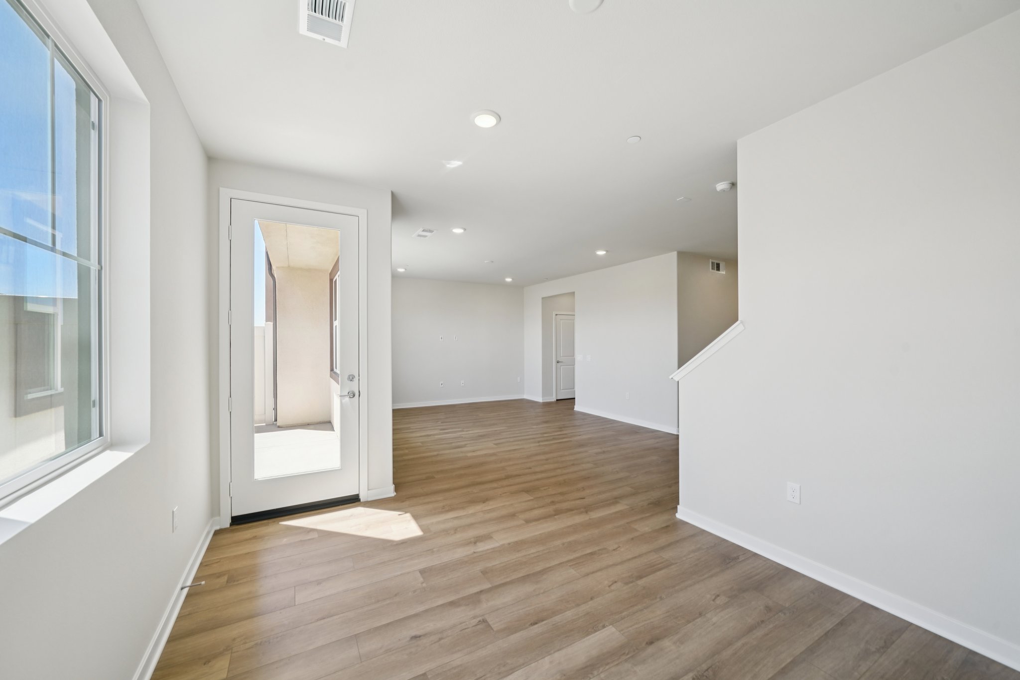 A room with a wood floor and white walls.