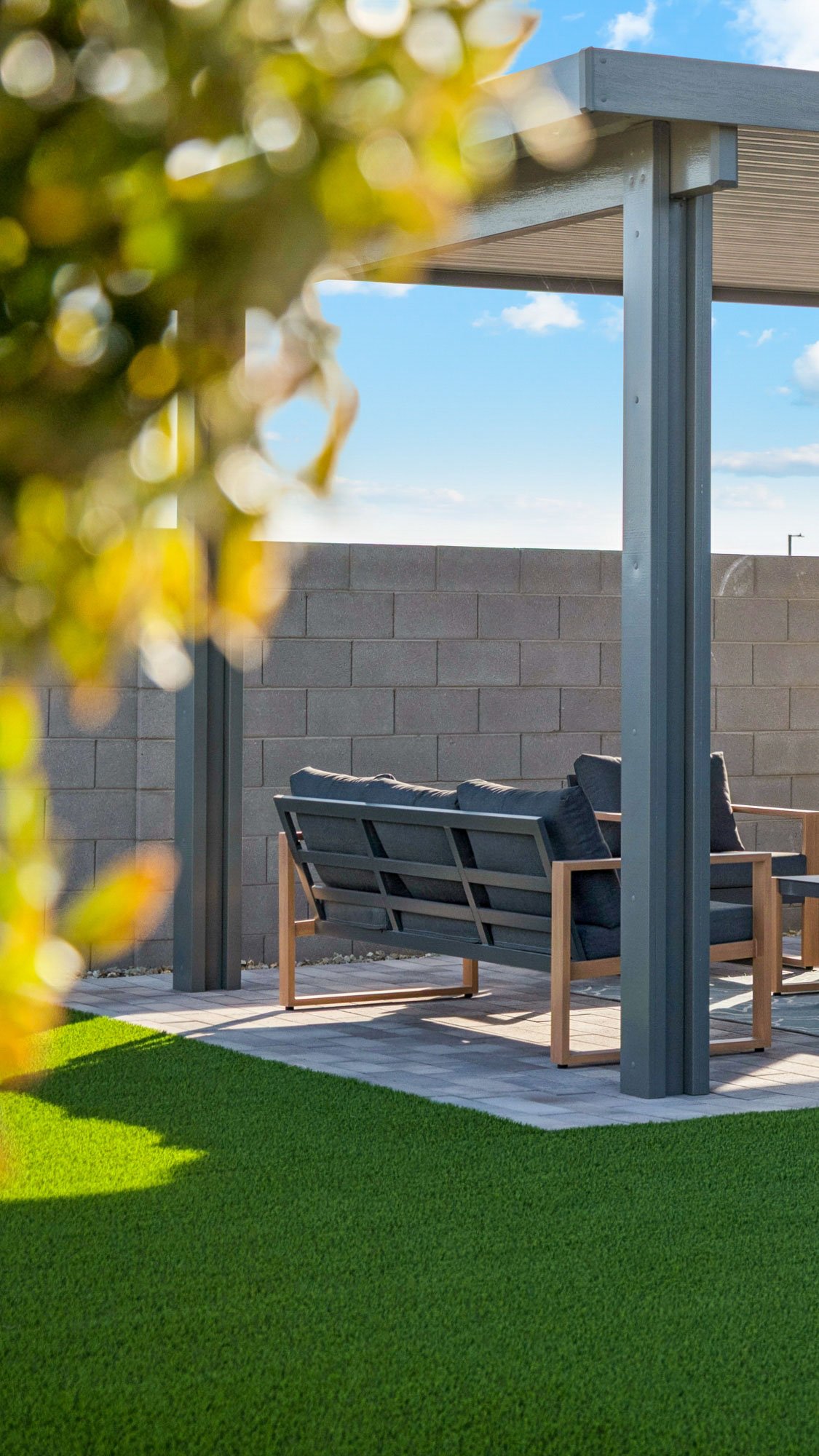 Photo of model home backyard with plenty of turf, patio furniture and mature foliage in Casa Grande AZ- New Construction Home For Sale by Century Communities with community amenities