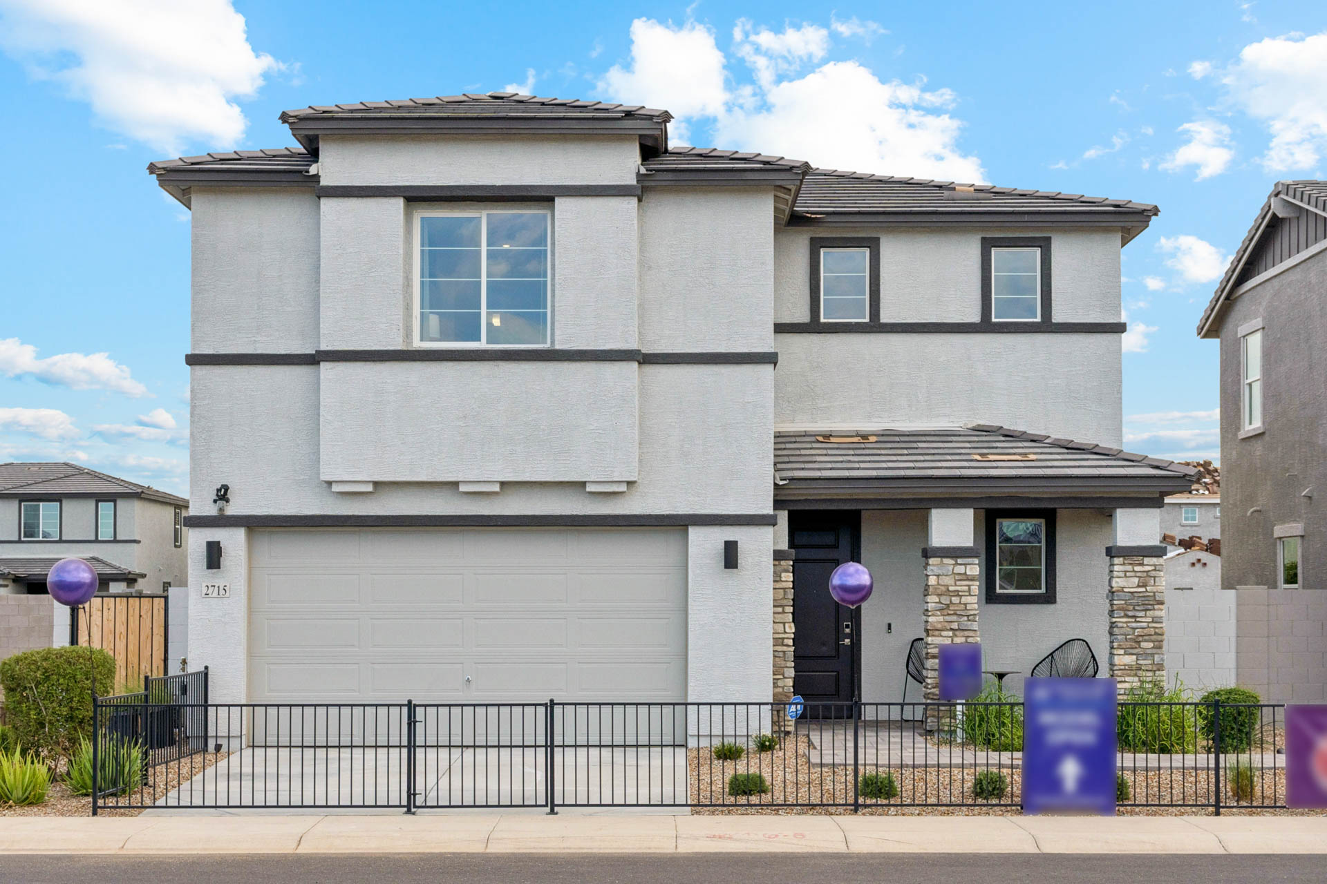 A white house with a black fence.