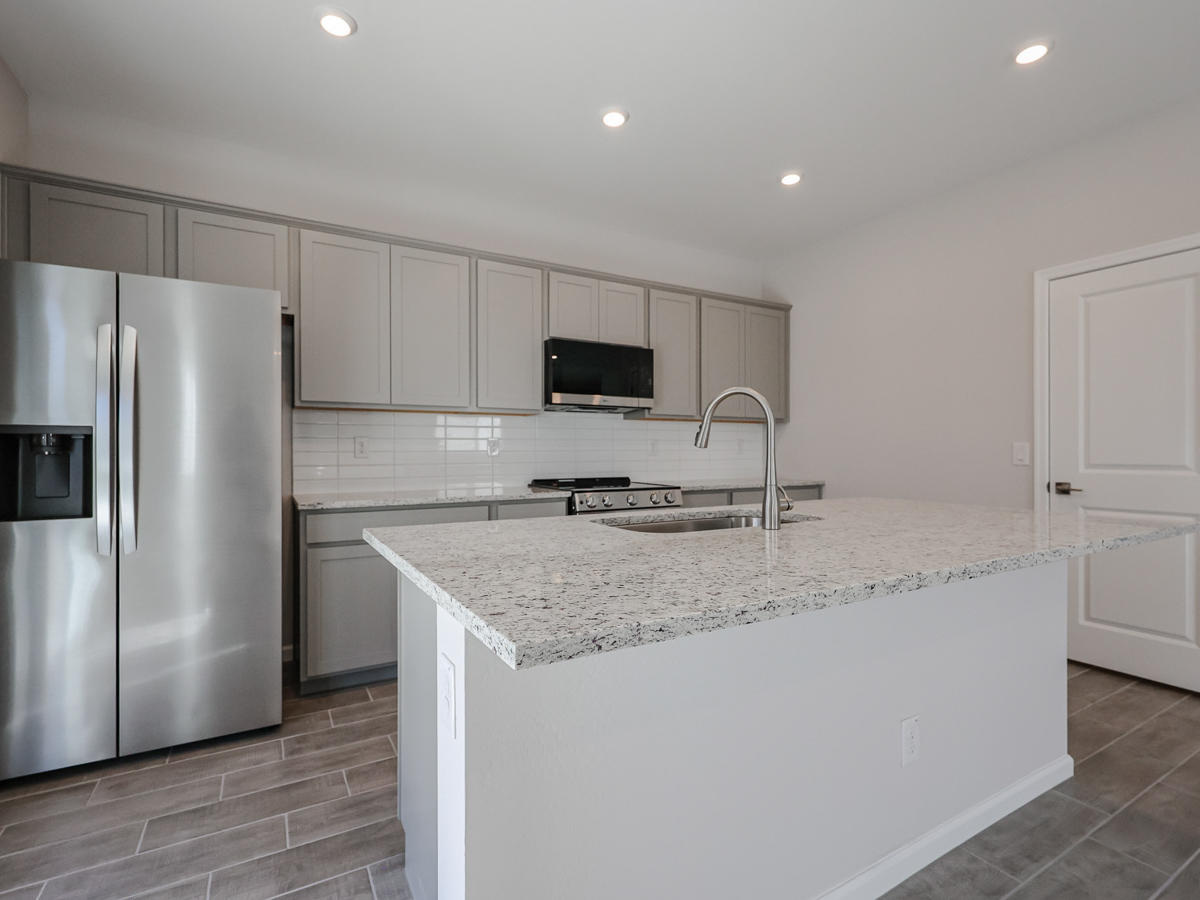 A kitchen with white cabinets.