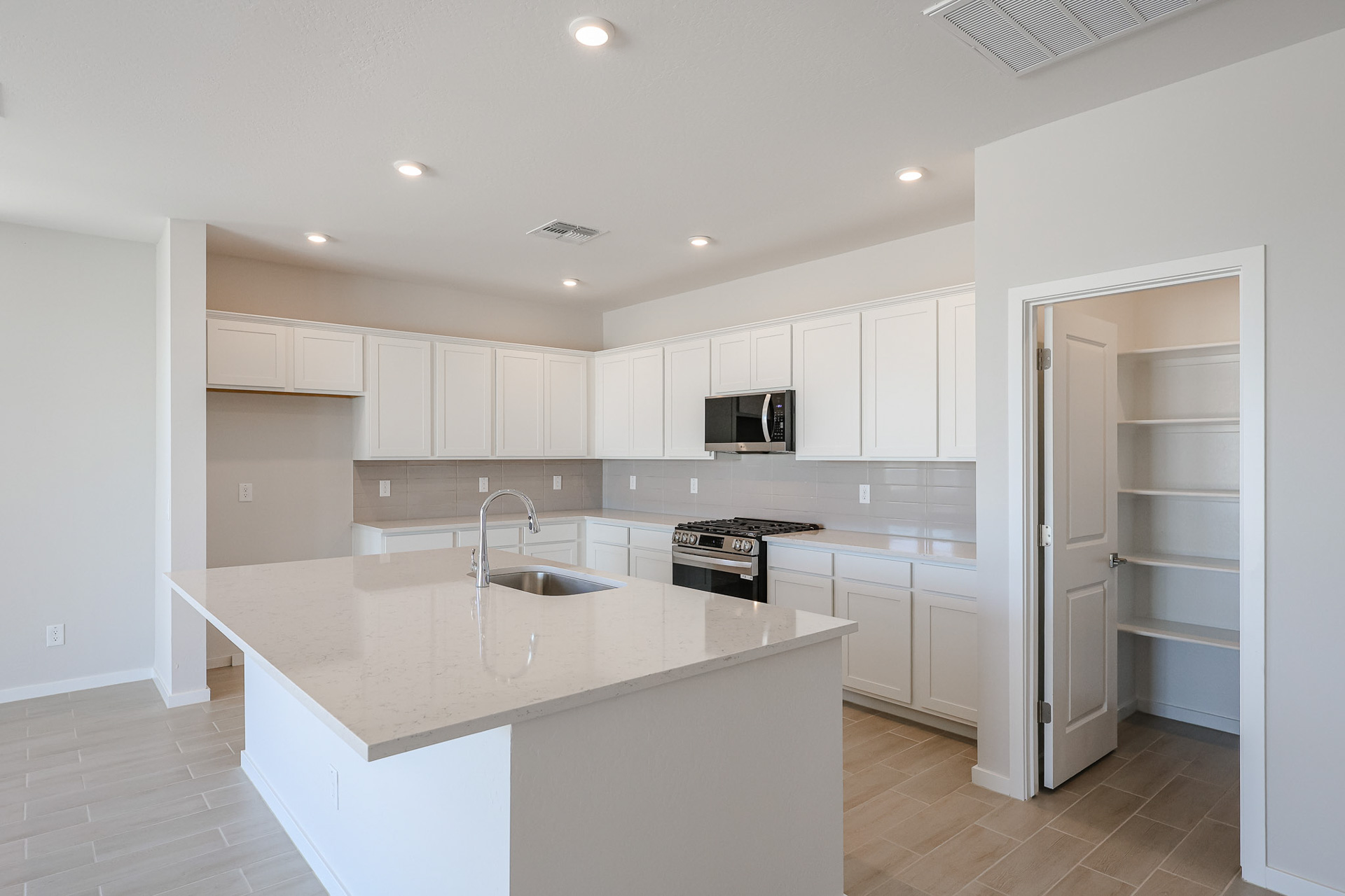 A kitchen with white cabinets.