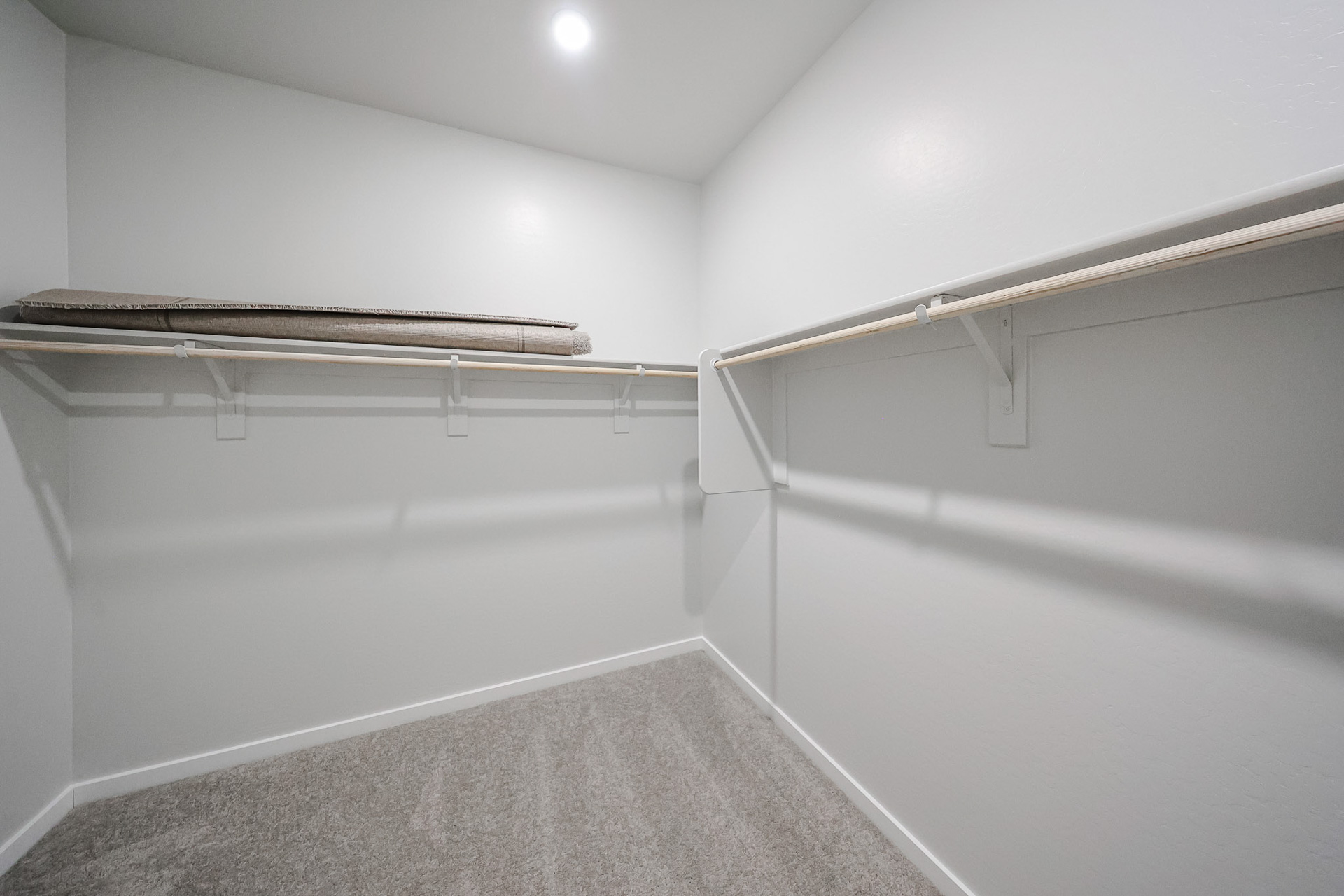 A white hallway with a metal railing.