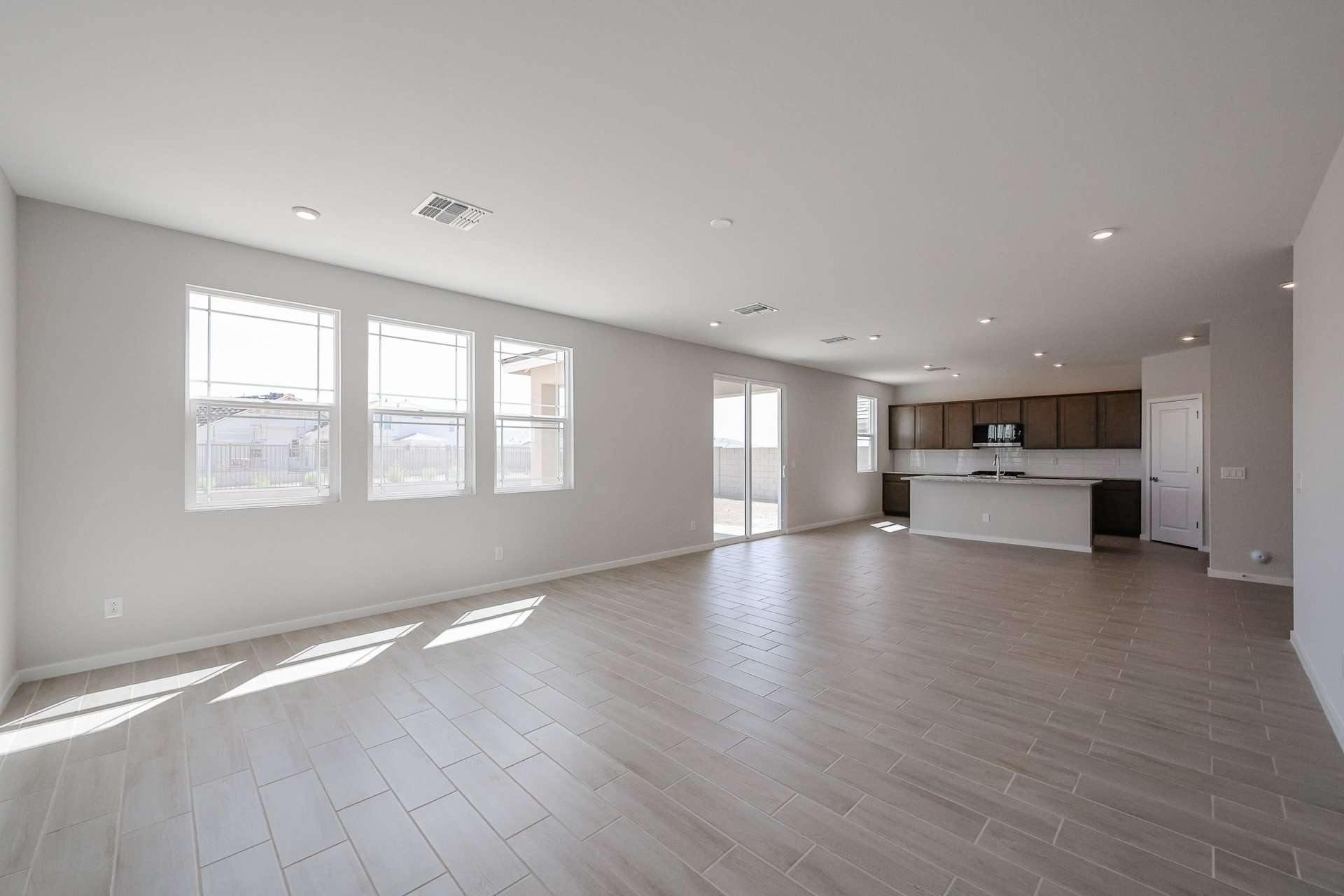 A large empty room with a wood floor and white walls.