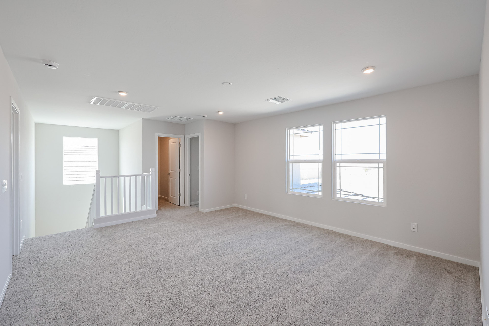 A room with a white wall and windows.