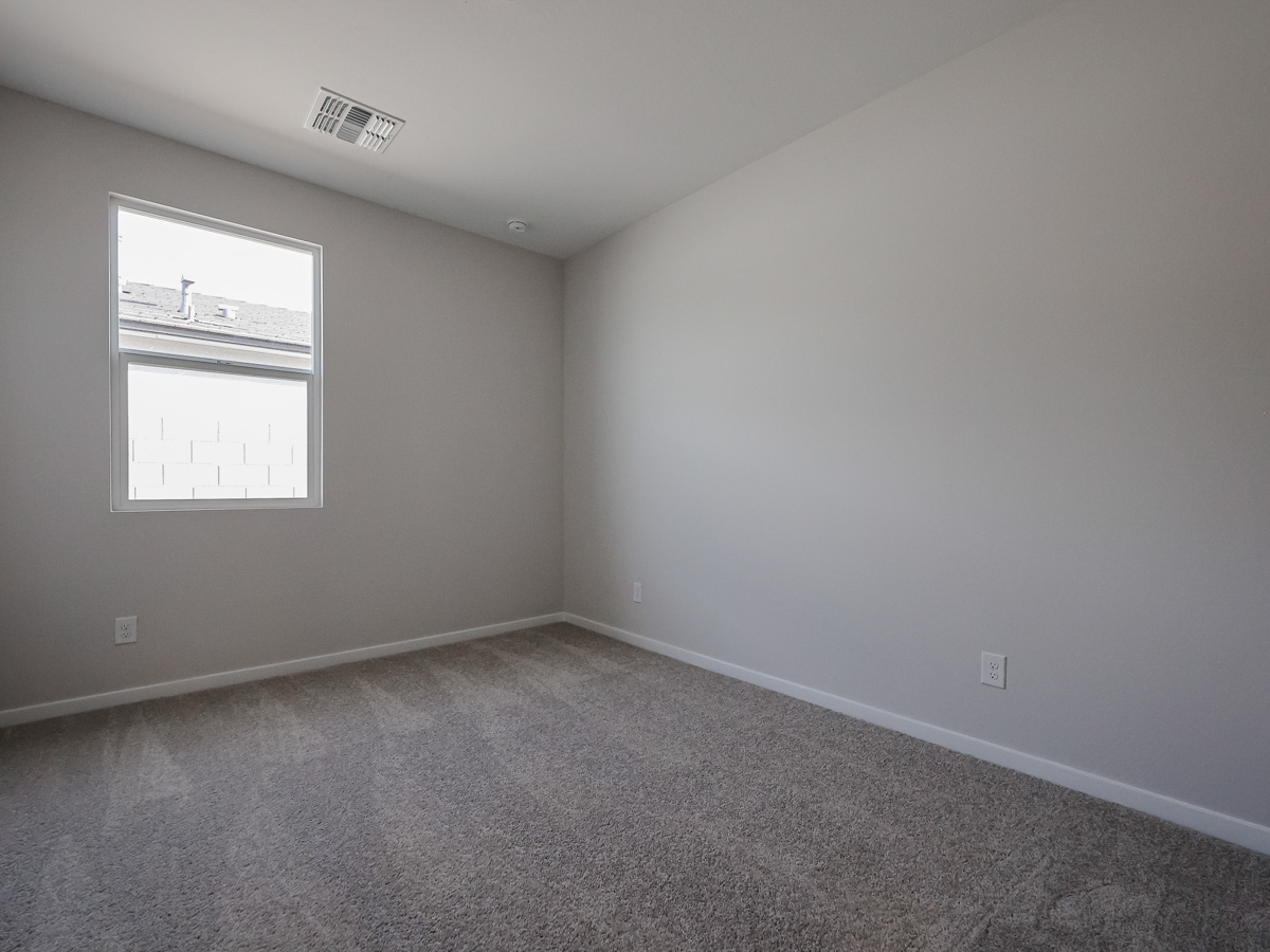 A room with a carpet and a window.
