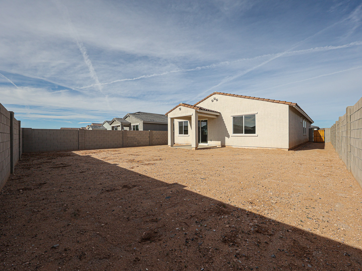 A dirt road with buildings on the side.