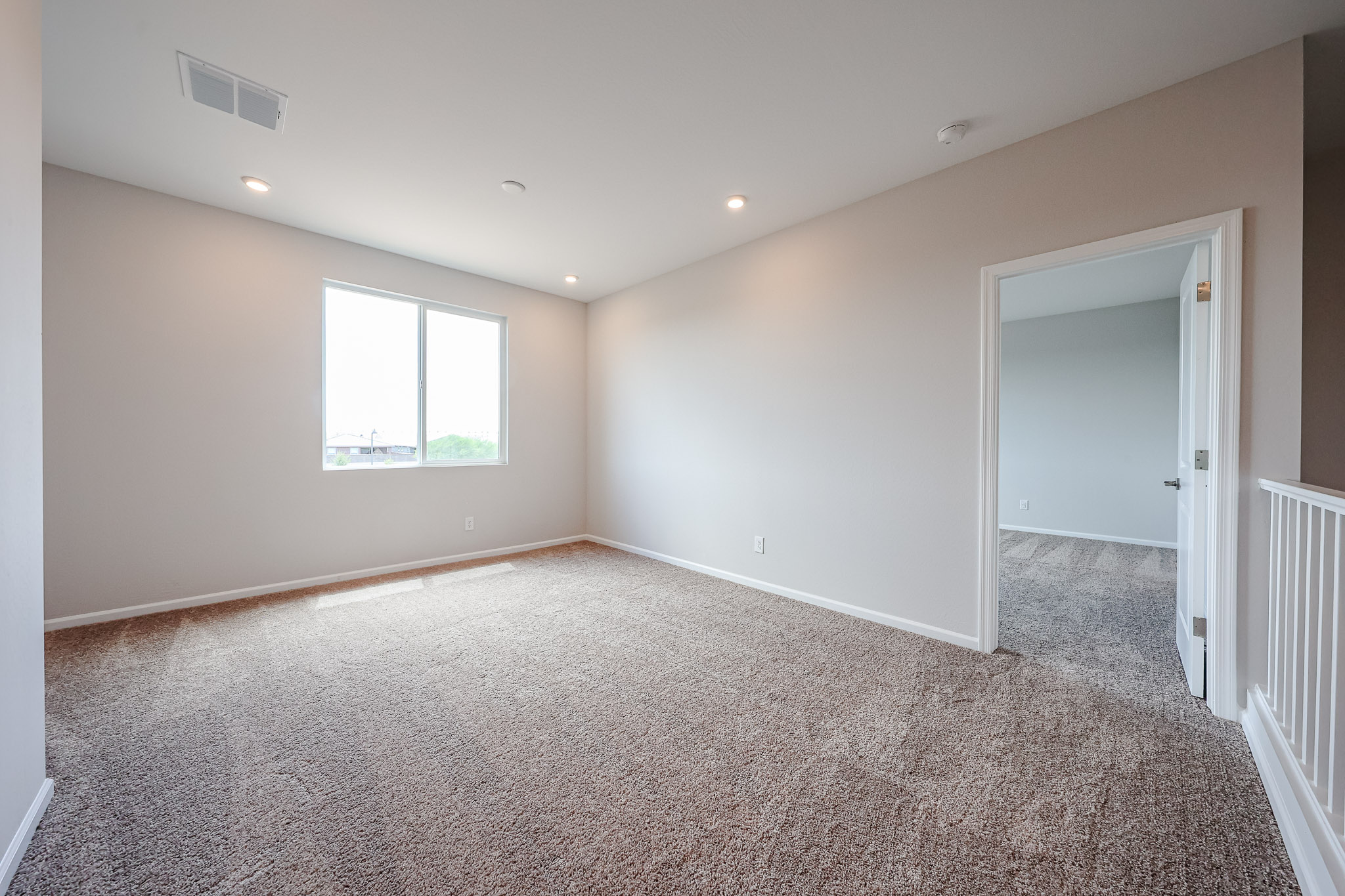 A room with a carpet and a door.