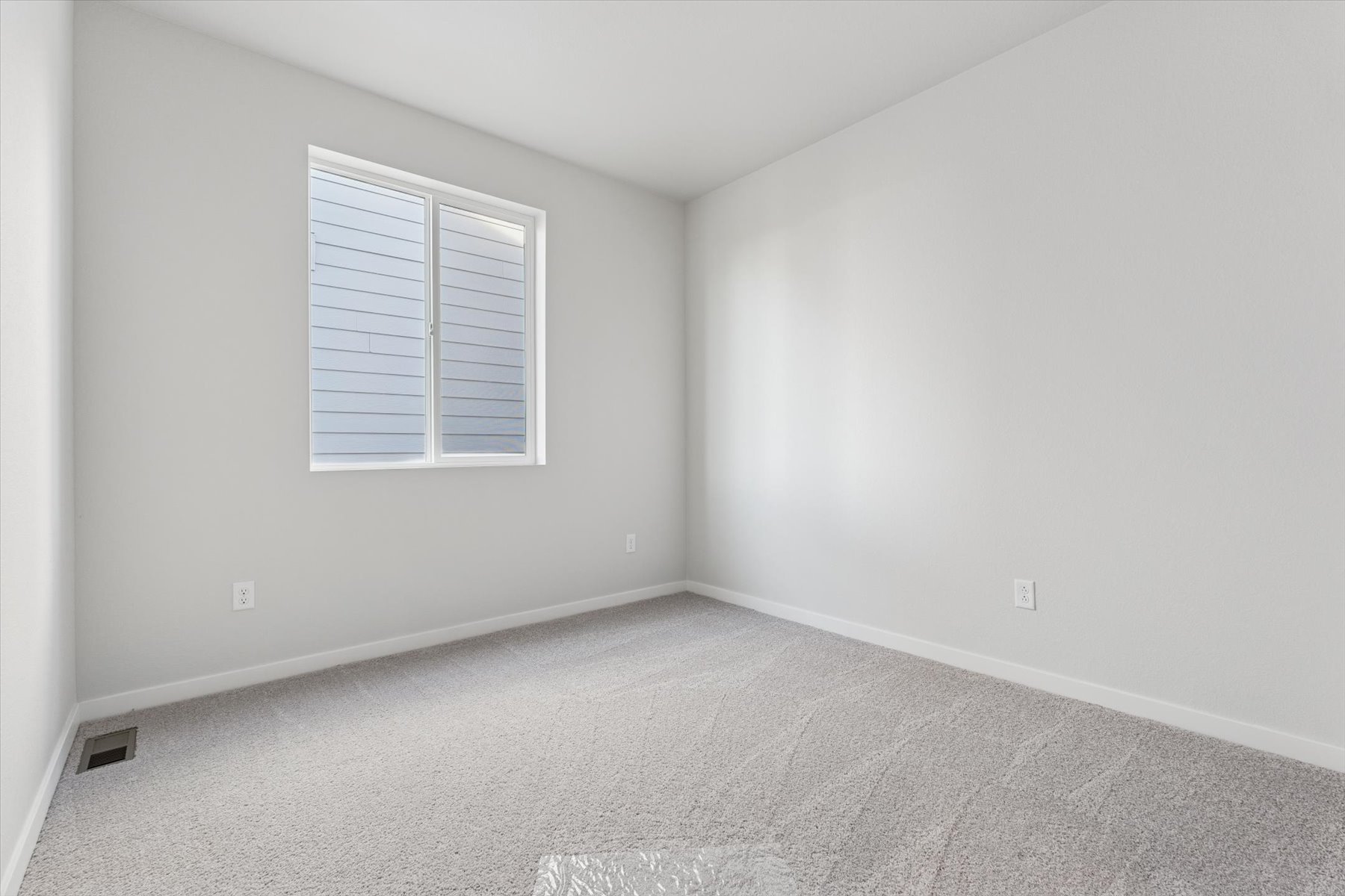 A room with a window and a carpet.