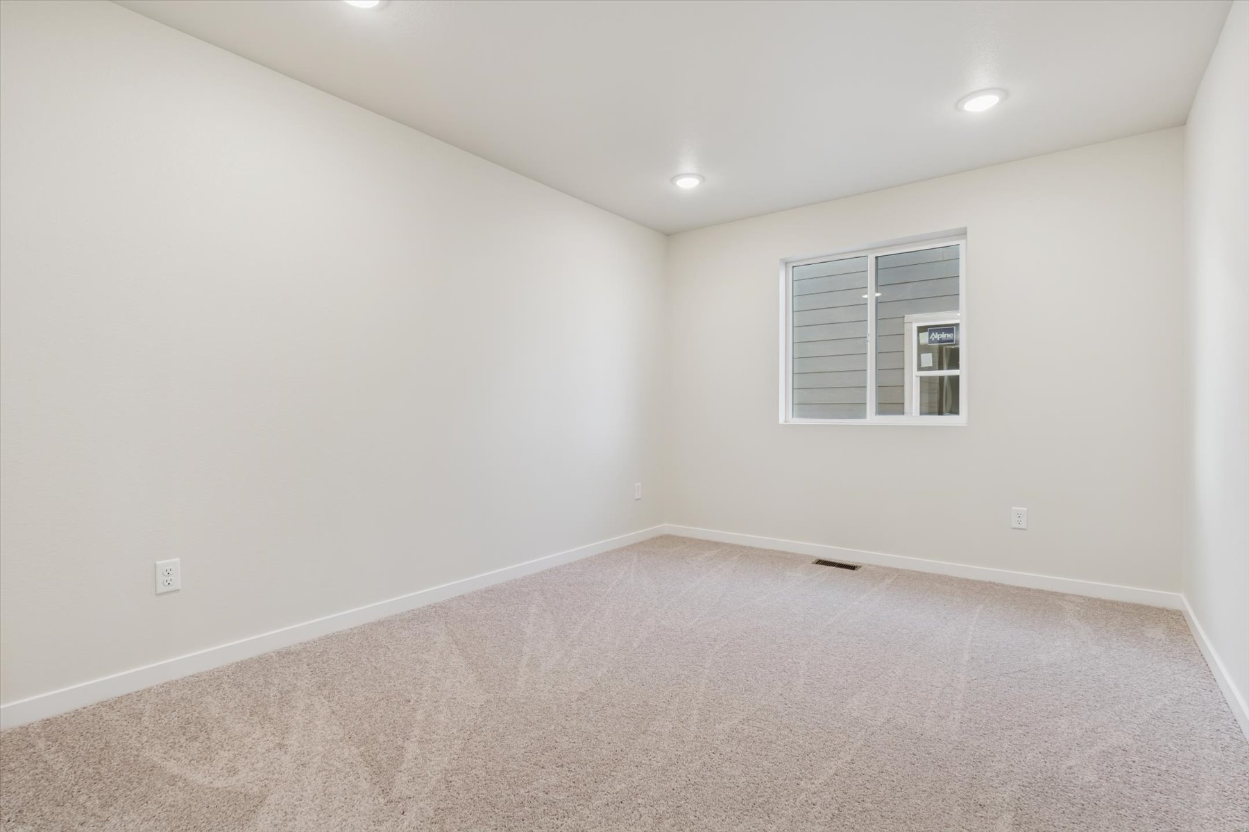 A room with a carpet and a window.