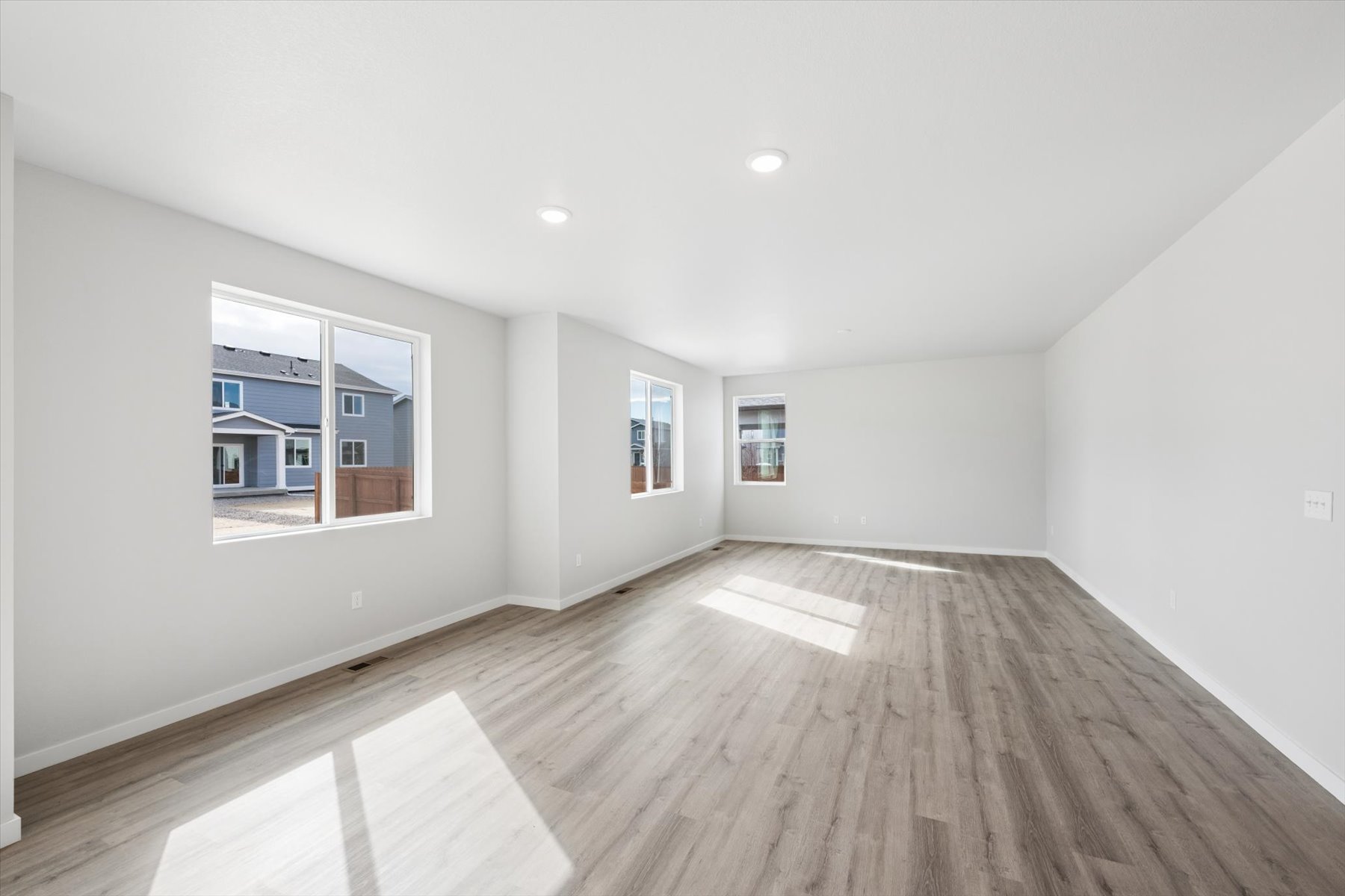 A room with a wood floor and windows.