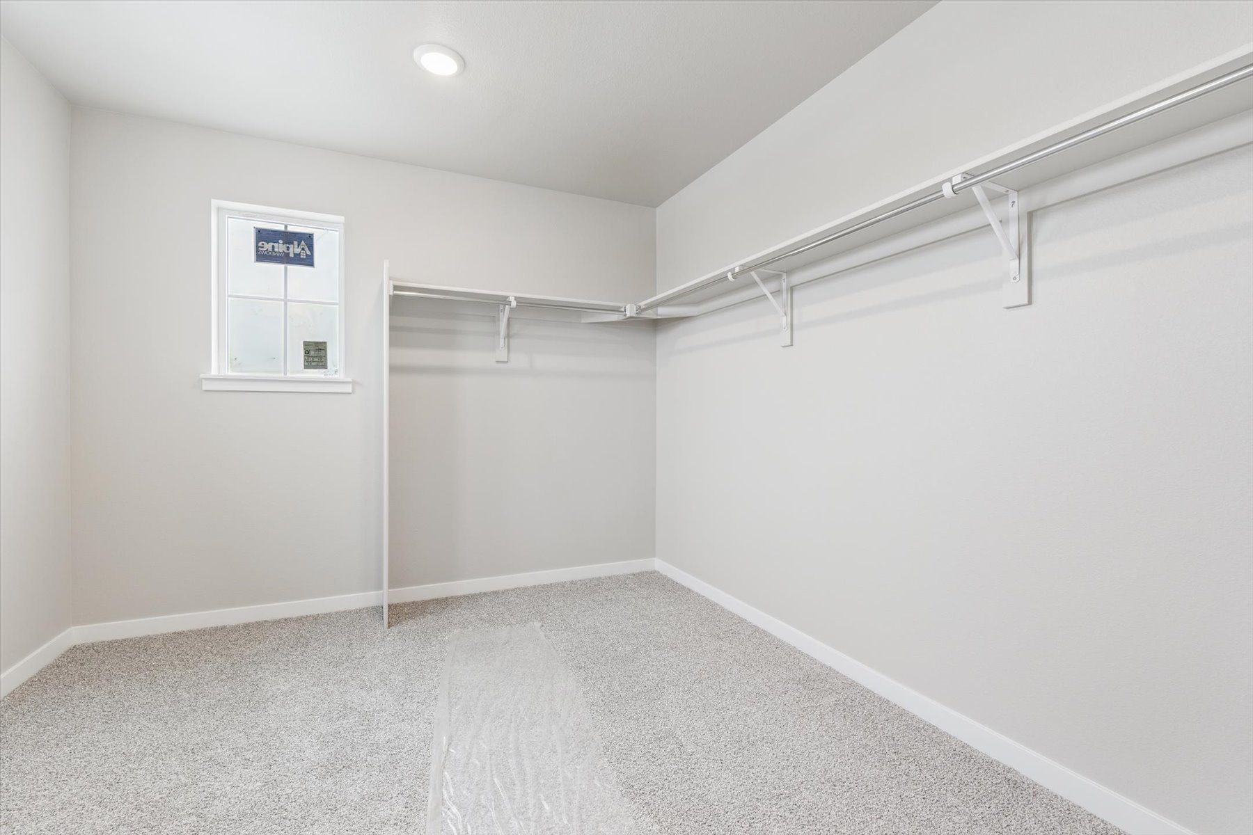 A white hallway with a metal railing.
