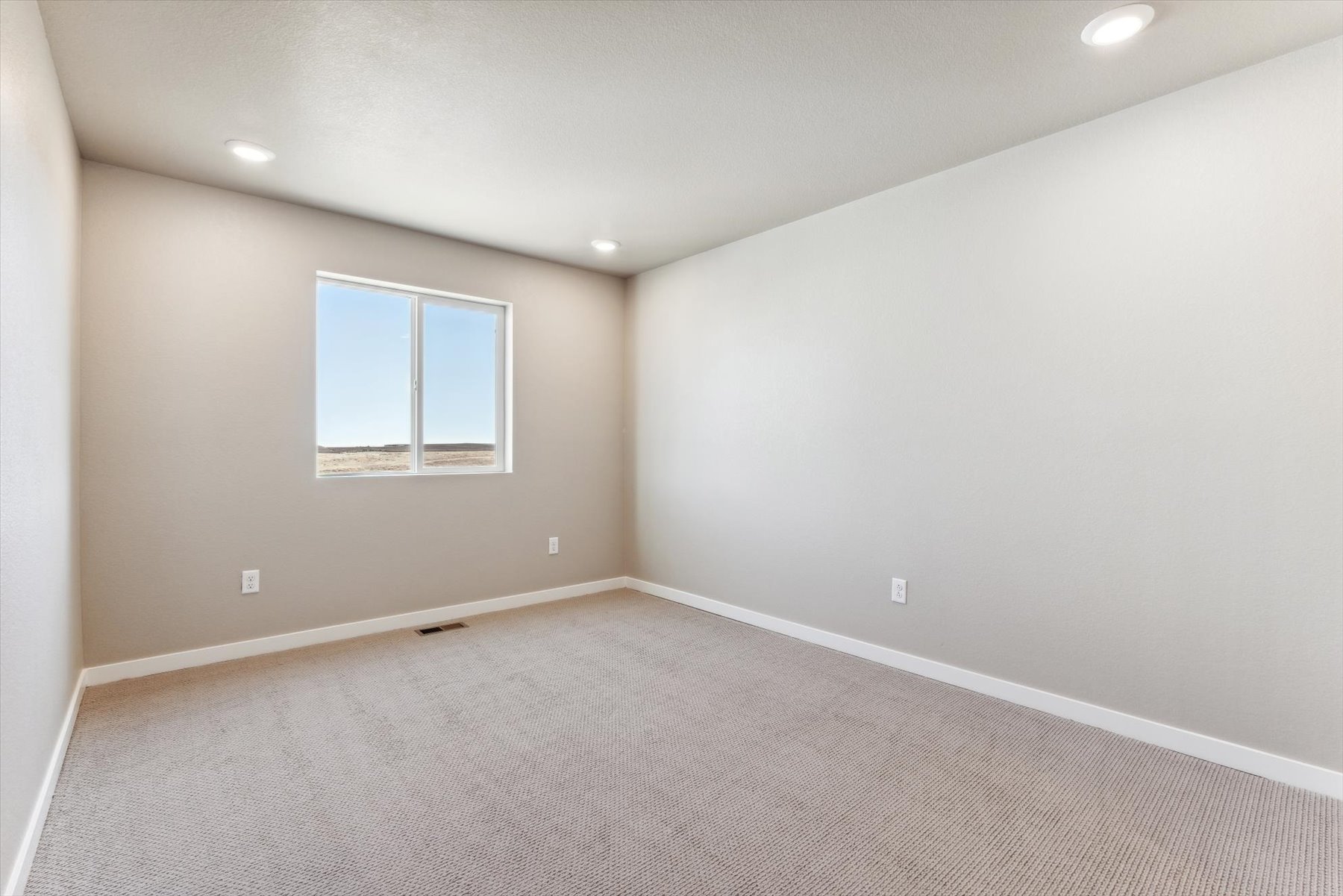 A room with a window and carpet.