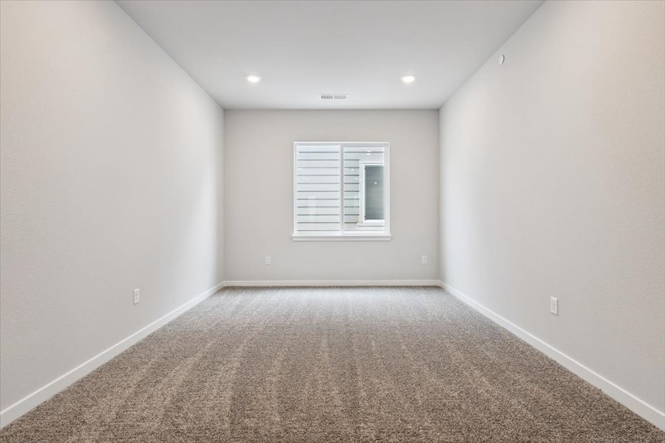 A room with a carpet and a window.