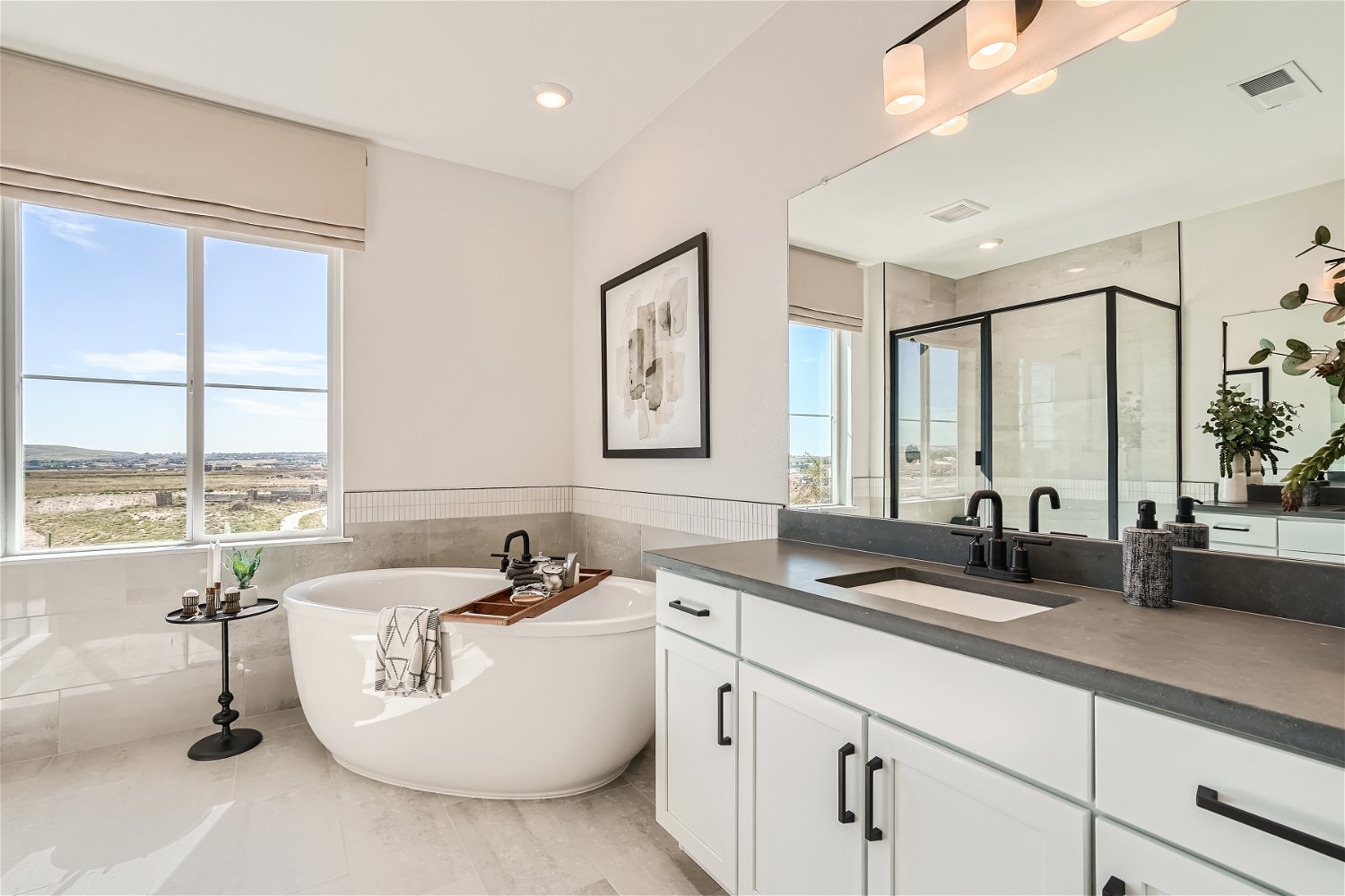 A bathroom with a tub sink and a large window.