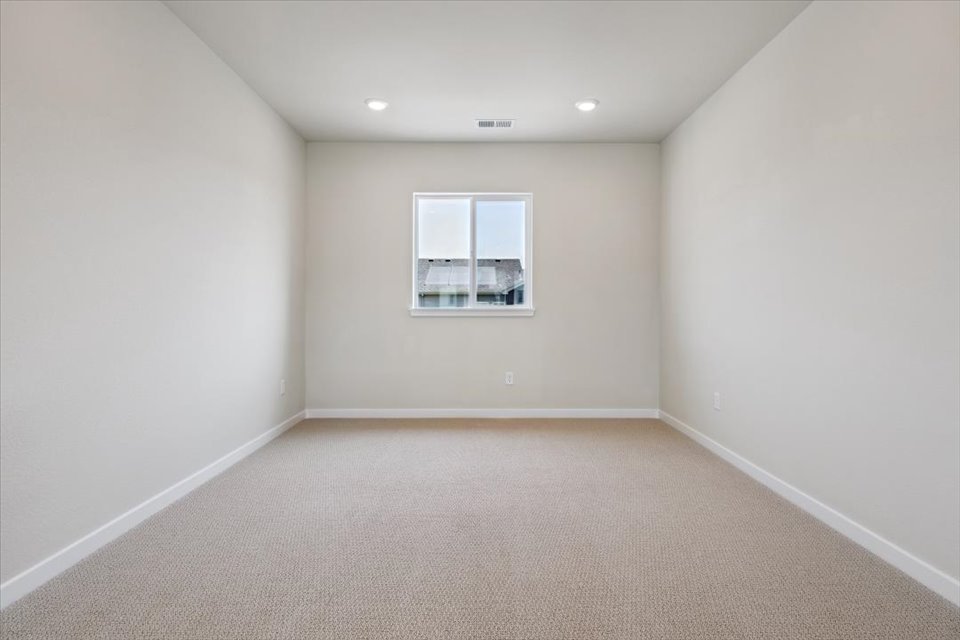 A room with a window and a carpet.