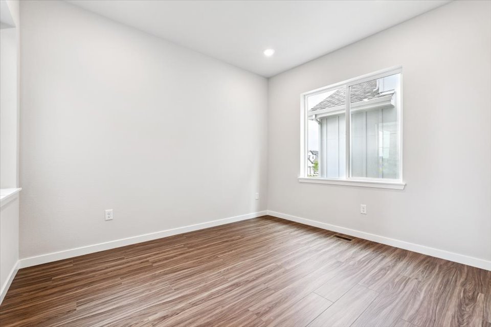 A room with a wood floor and a window.