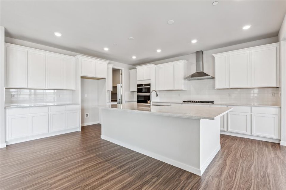 A kitchen with white cabinets.