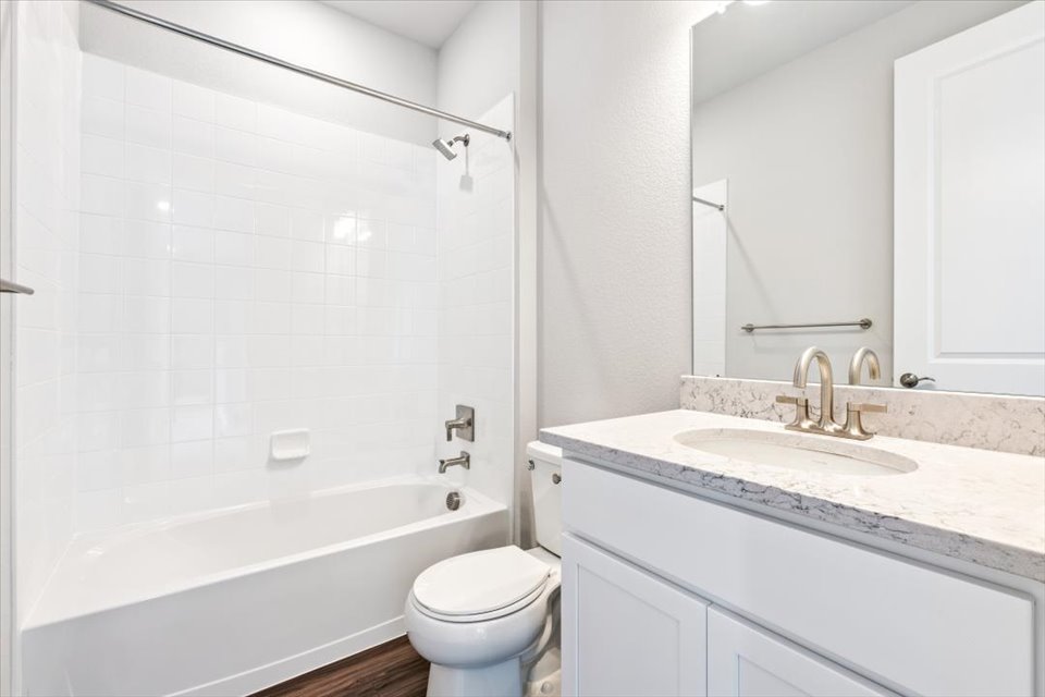 A bathroom with a tub sink and toilet.