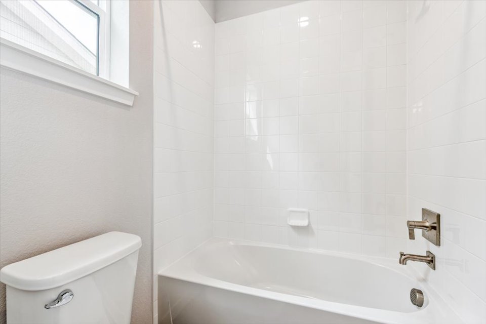 A bathroom with a tub and toilet.