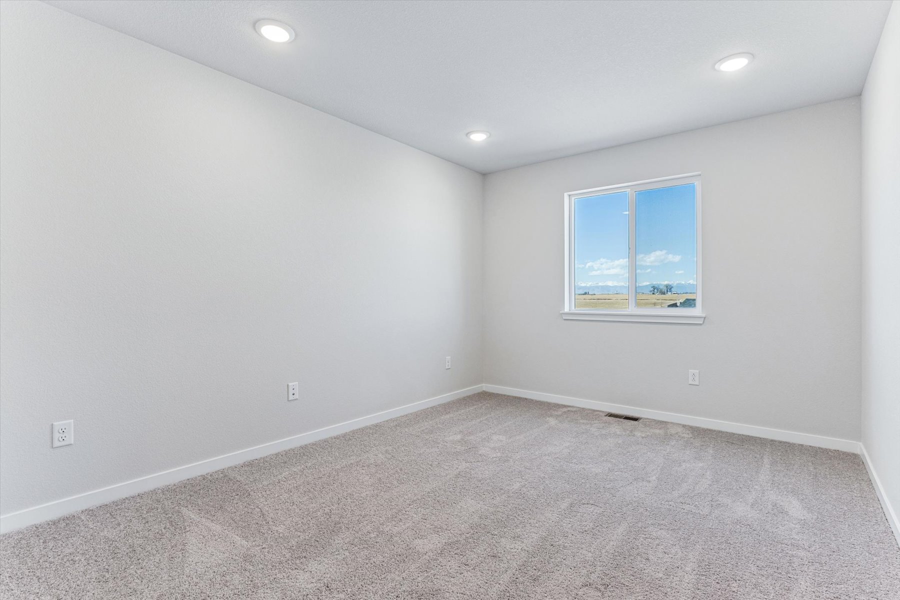 A room with a window and a carpet.