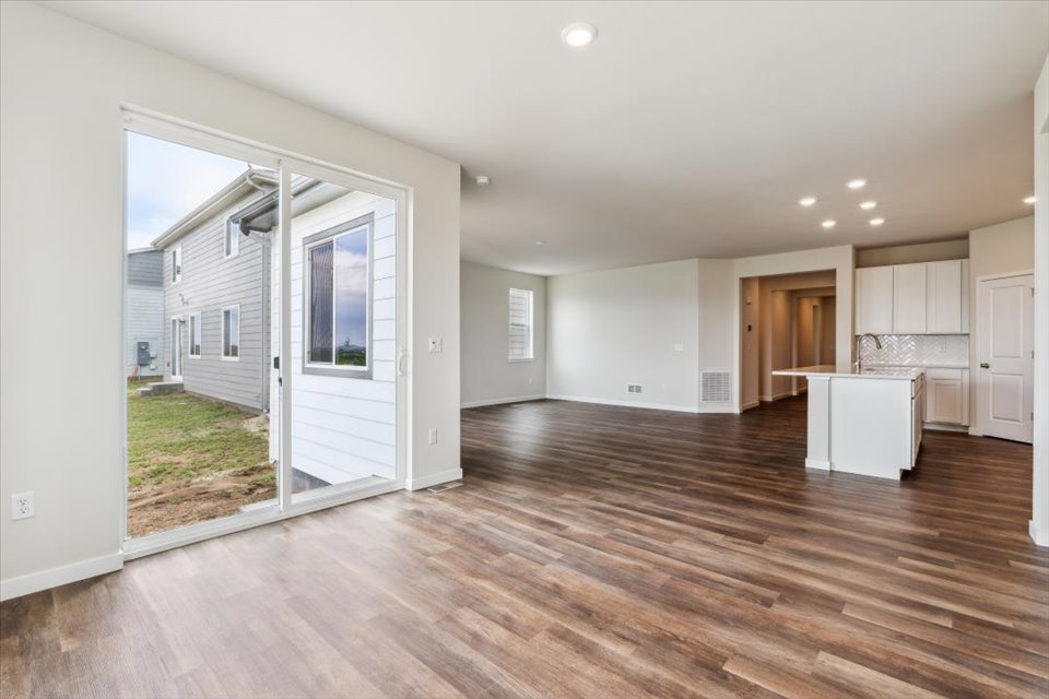 A large empty room with a wood floor and white walls.
