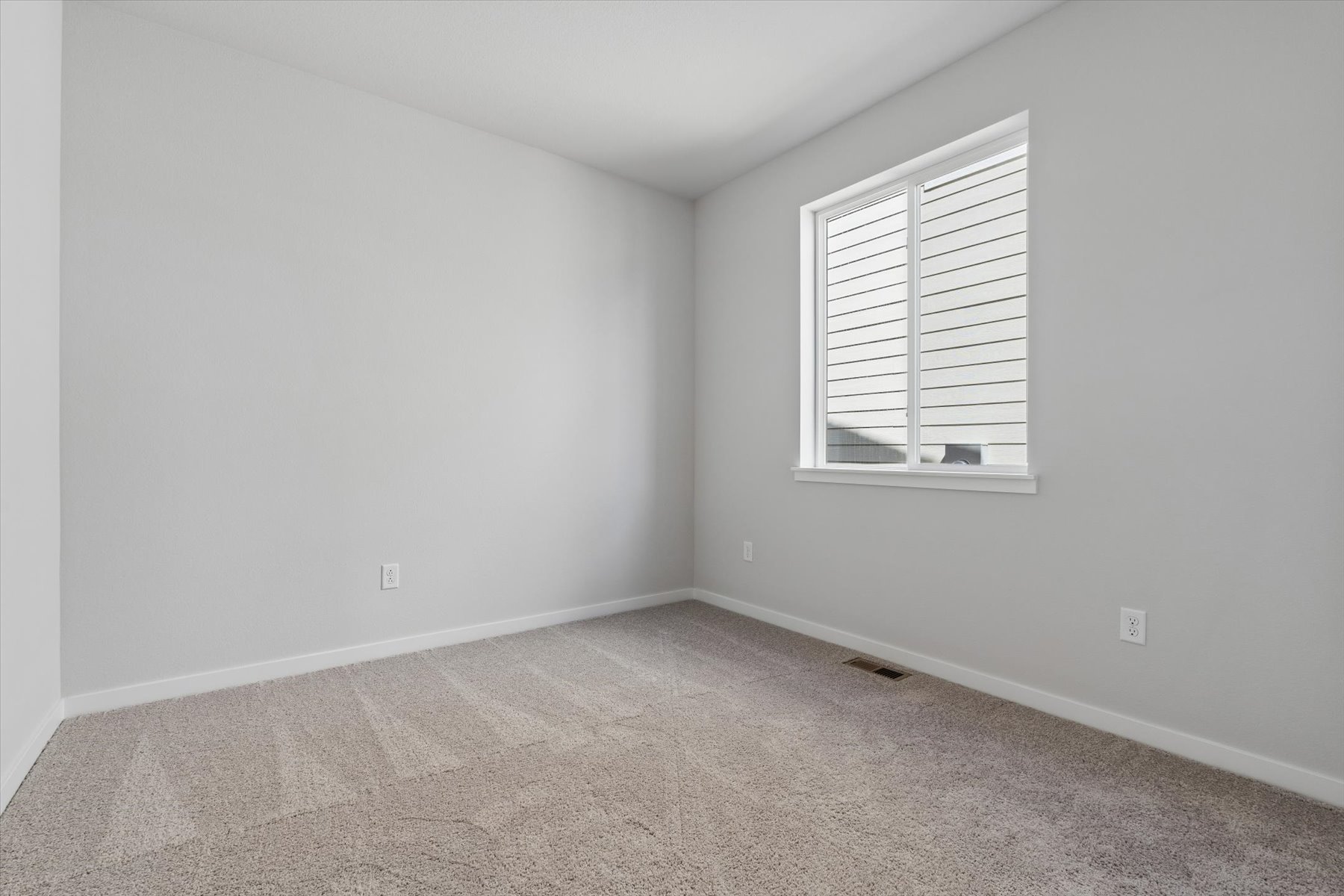A room with a window and carpet.