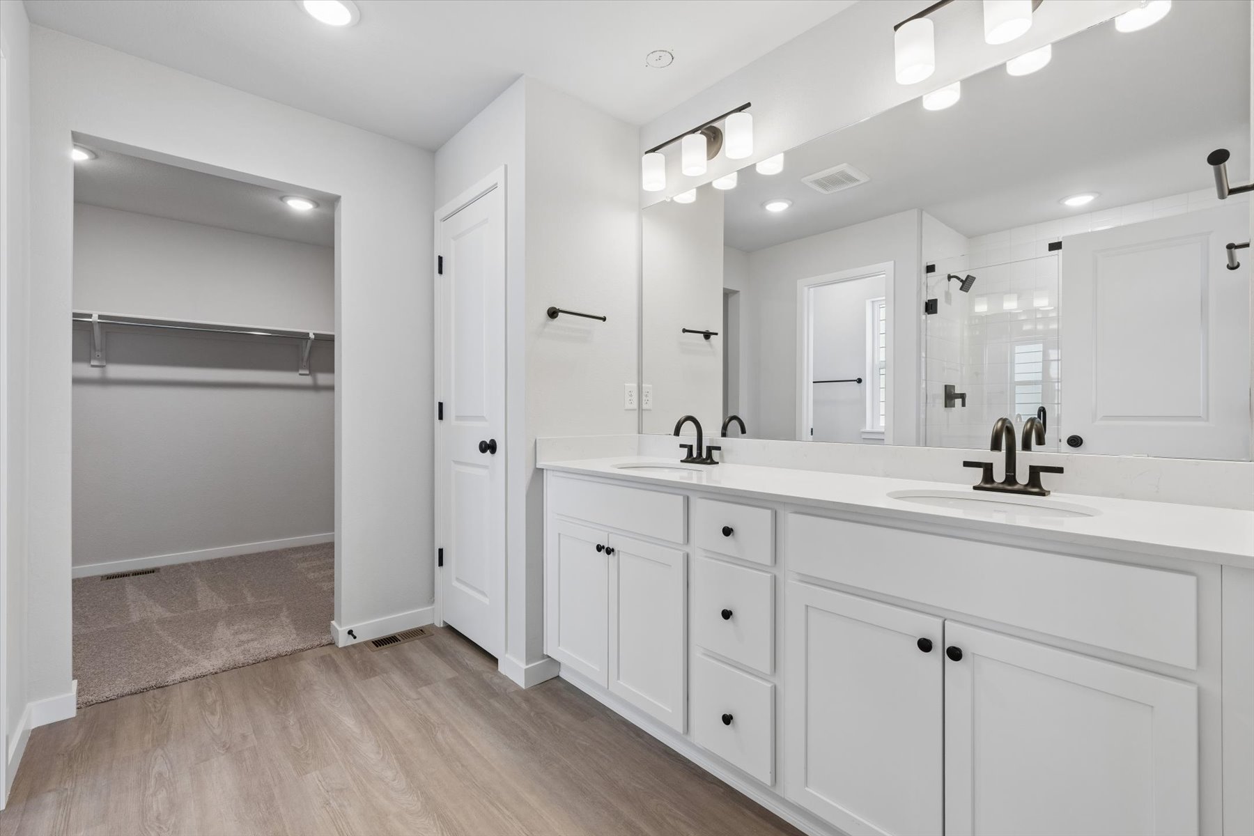 A bathroom with white cabinets.