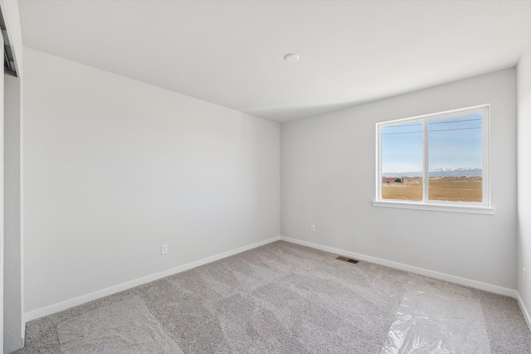 A room with a window and a carpet.