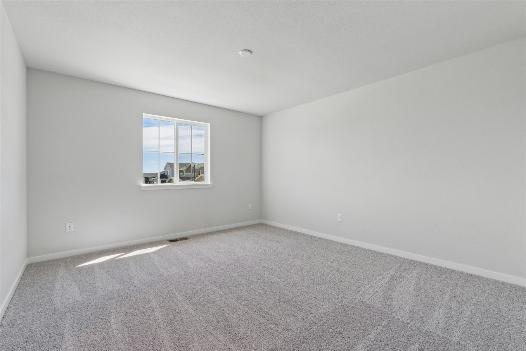 A room with a window and carpet.