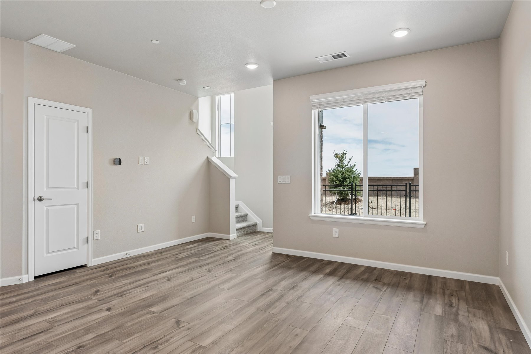 A room with a wood floor and a wood floor with a window.