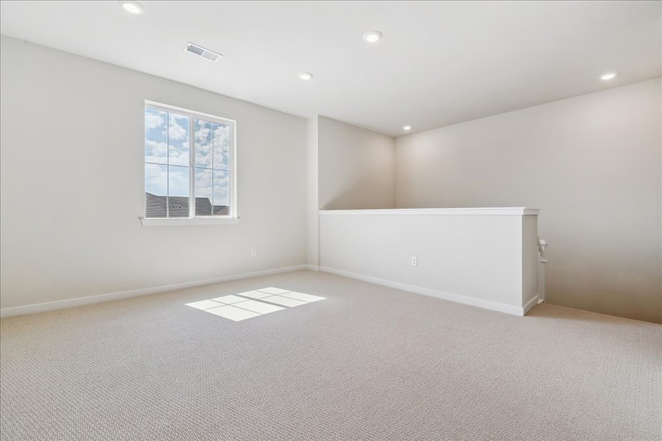 A room with a window and a white wall.